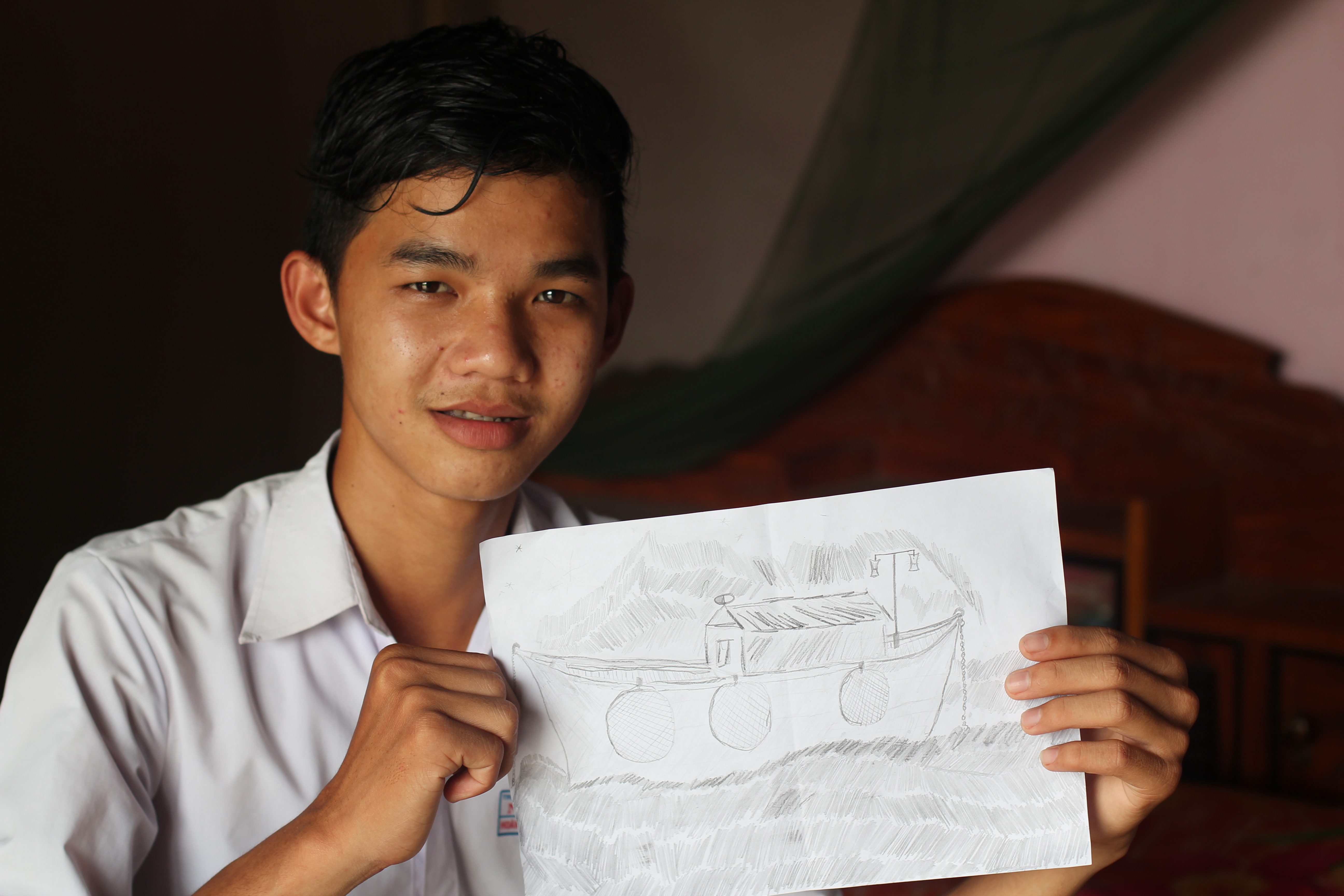 Thinh shows his drawing about the fishing boat where he stayed and trapped to work for the owner of the boat. He has used the drawing as a presentation to share his story as a lesson-learnt for his peers. 
