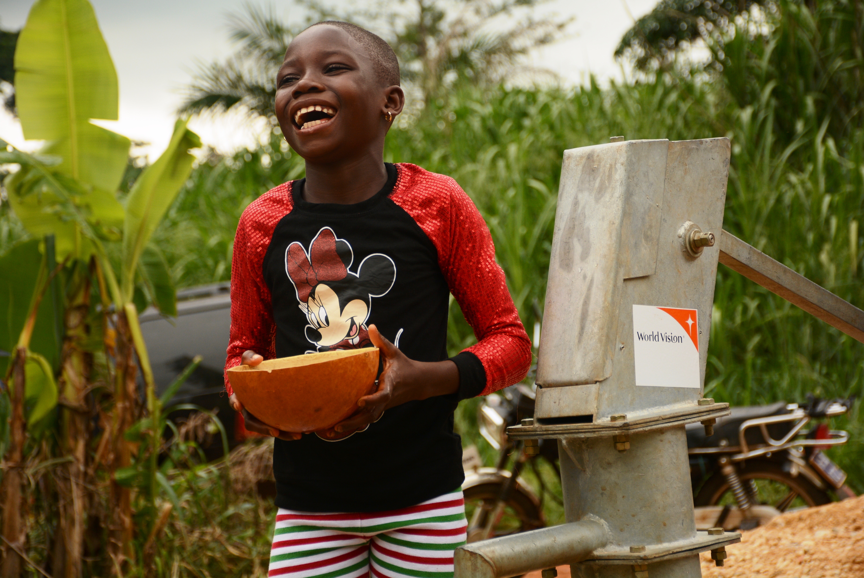 A child excited to drink the first flow of water from the bore hole constructed by World Vision in partnership with Accra Brewery Limited.
