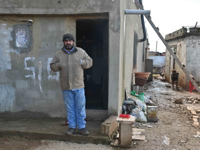 Rabih standing in front of his humble house
