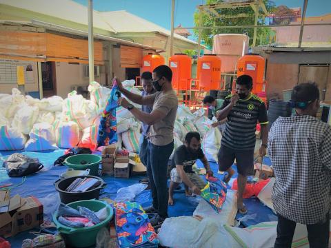 World Vision’s Abilio Marques (standing in the middle while holding cloth) and the team packing the items.
