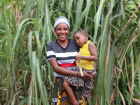 Emeliciana Zimbwe (33) with her daughter Neema (4) in front of their sugar cane field enjoying a moment together (Photo by Olivia Kassano) 