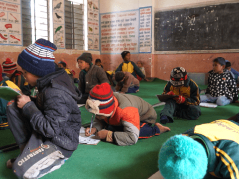 Children from Nepal studying on the floor