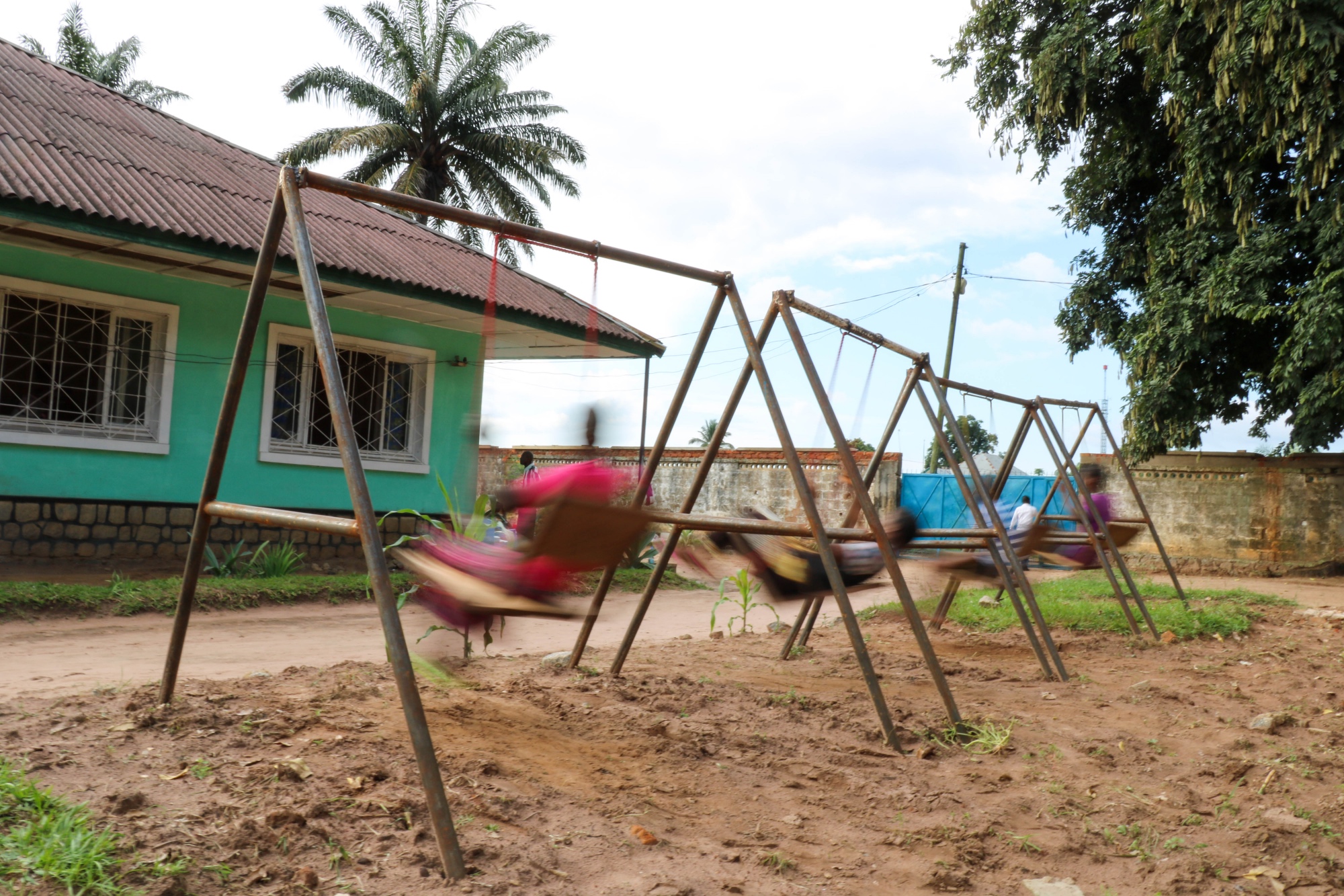 Four former militia members play on the swings at a centre for demobilised children in Kasai Central.  Forcibly recruited or eager militia member, physical or psychological injuries, all four of them are laughing and playing together.