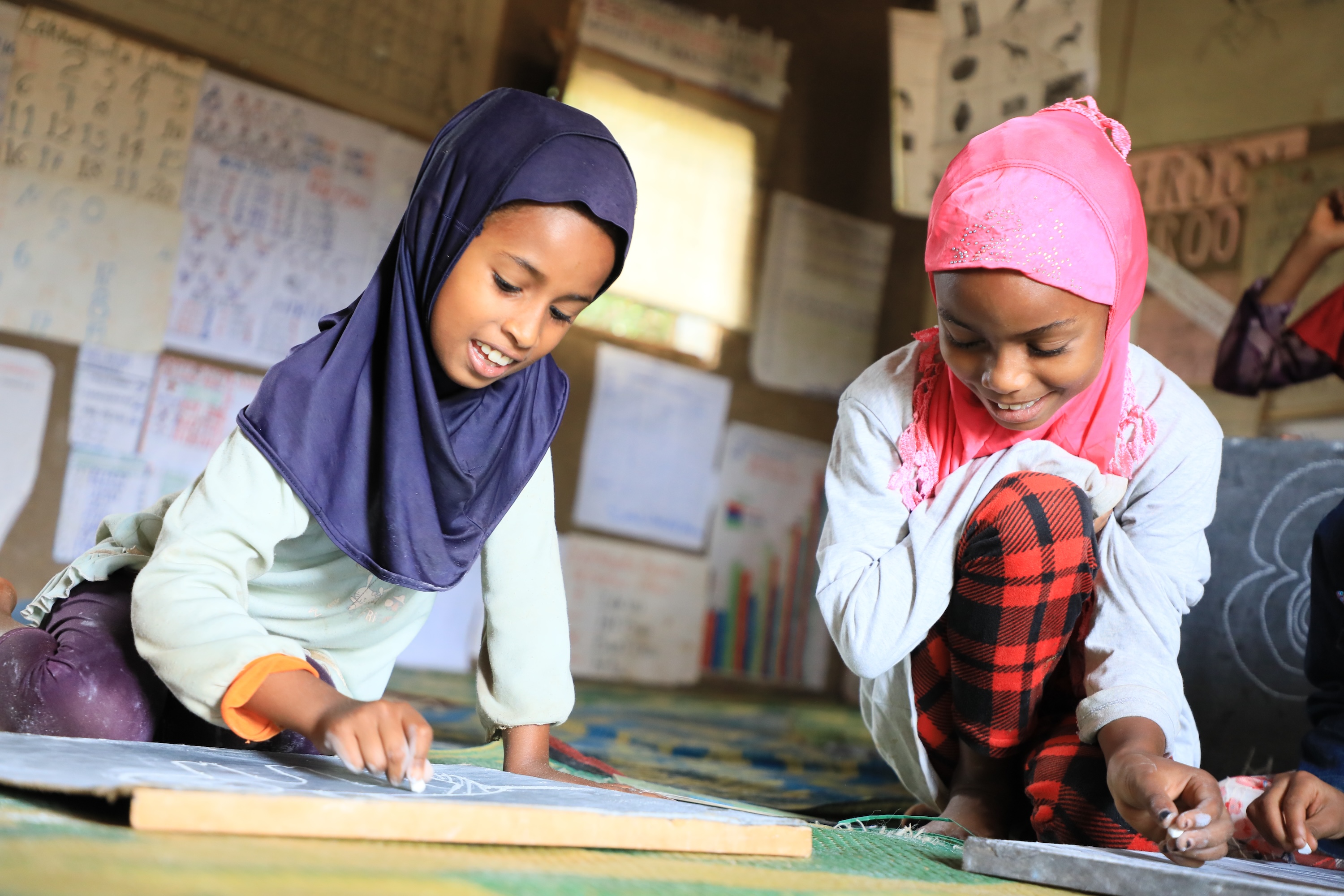 Anila and her friends drawing at the reading camp