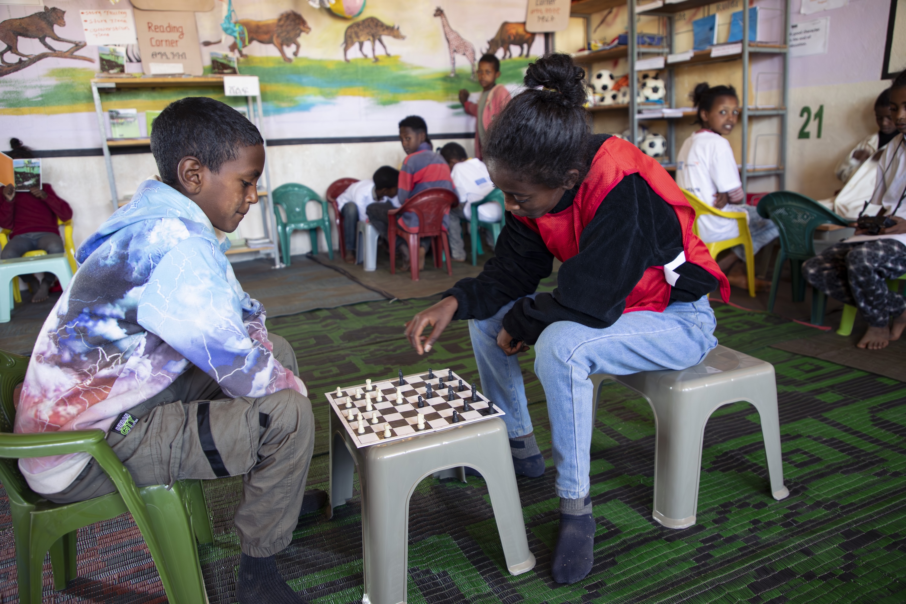 Lidiya playing chess with her friend at the Child Friendly Space