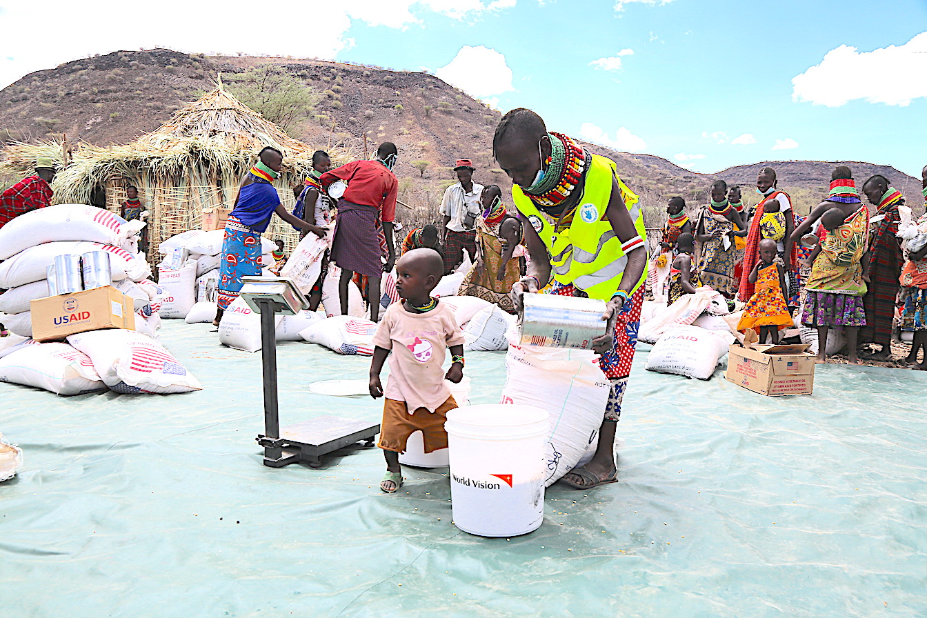 During food distribution, priority is given to vulnerable populations that include young children. Amanikor is happy to collect food for her children and family.©World Vision photo/Martin Muluka.