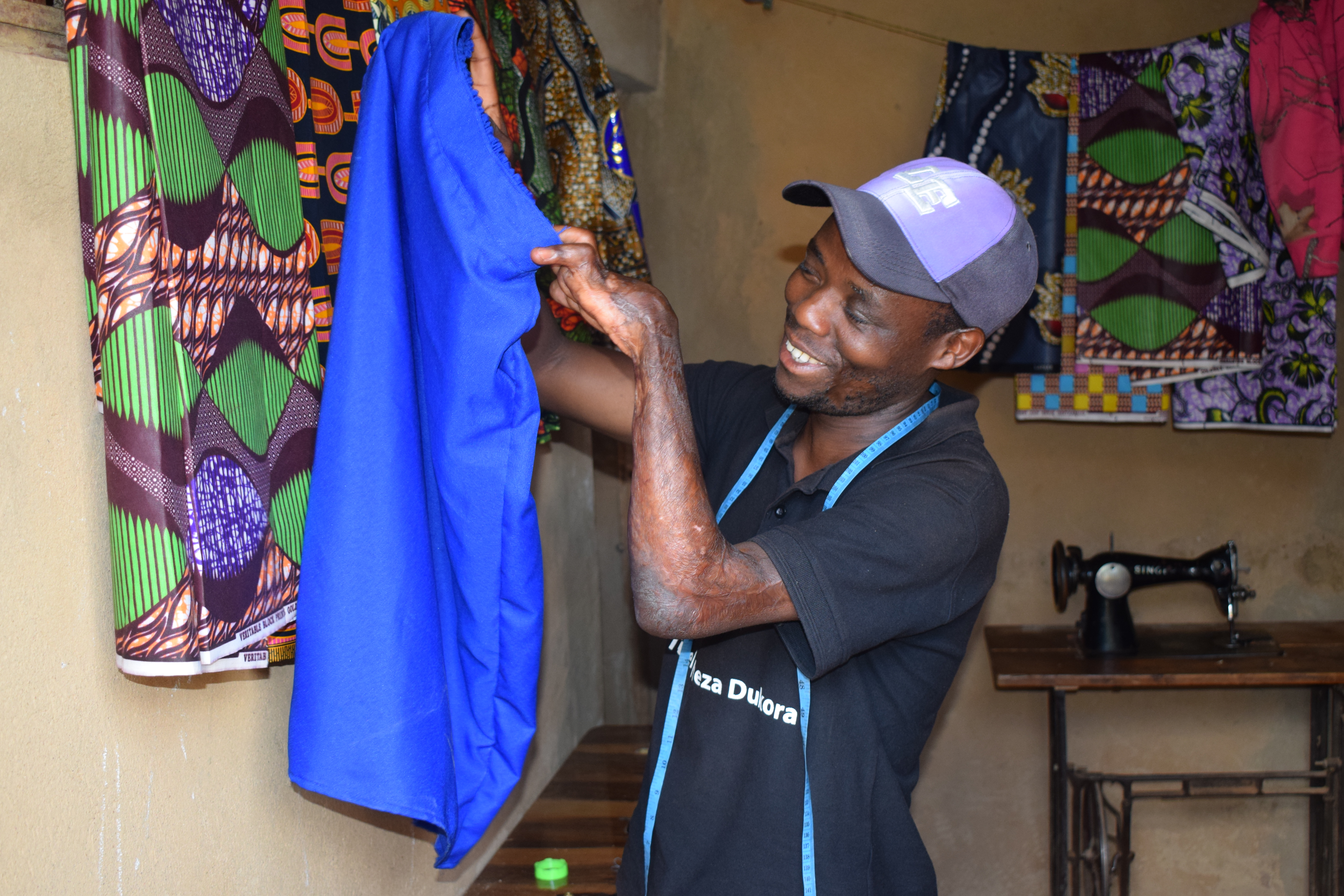 Tuyisenge showing a skirt that he just  made.