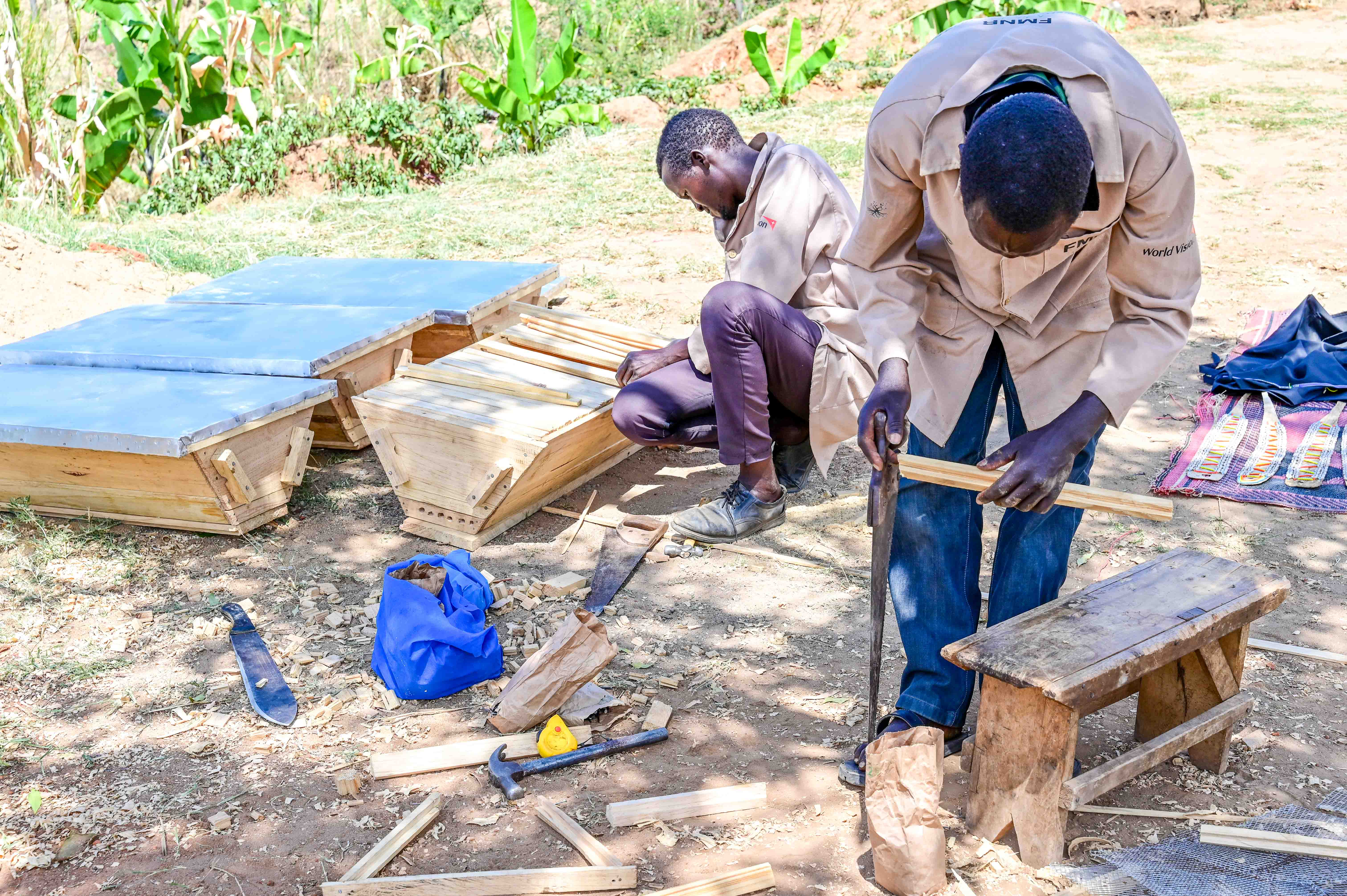 Richard Mnang’at and Samwel Musto constructing a Kenya Top Bar Hive for a lead farmer in her homestead in West Pokot County at a cost of 1,000 KES (7.72 USD) per hive. ©World Vision Photo/ Hellen Owuor