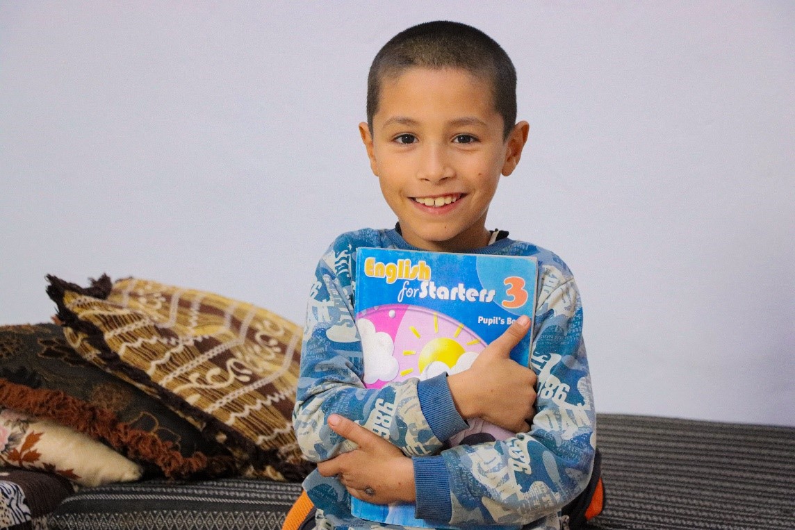 Figure 5: Badr happily holding his book