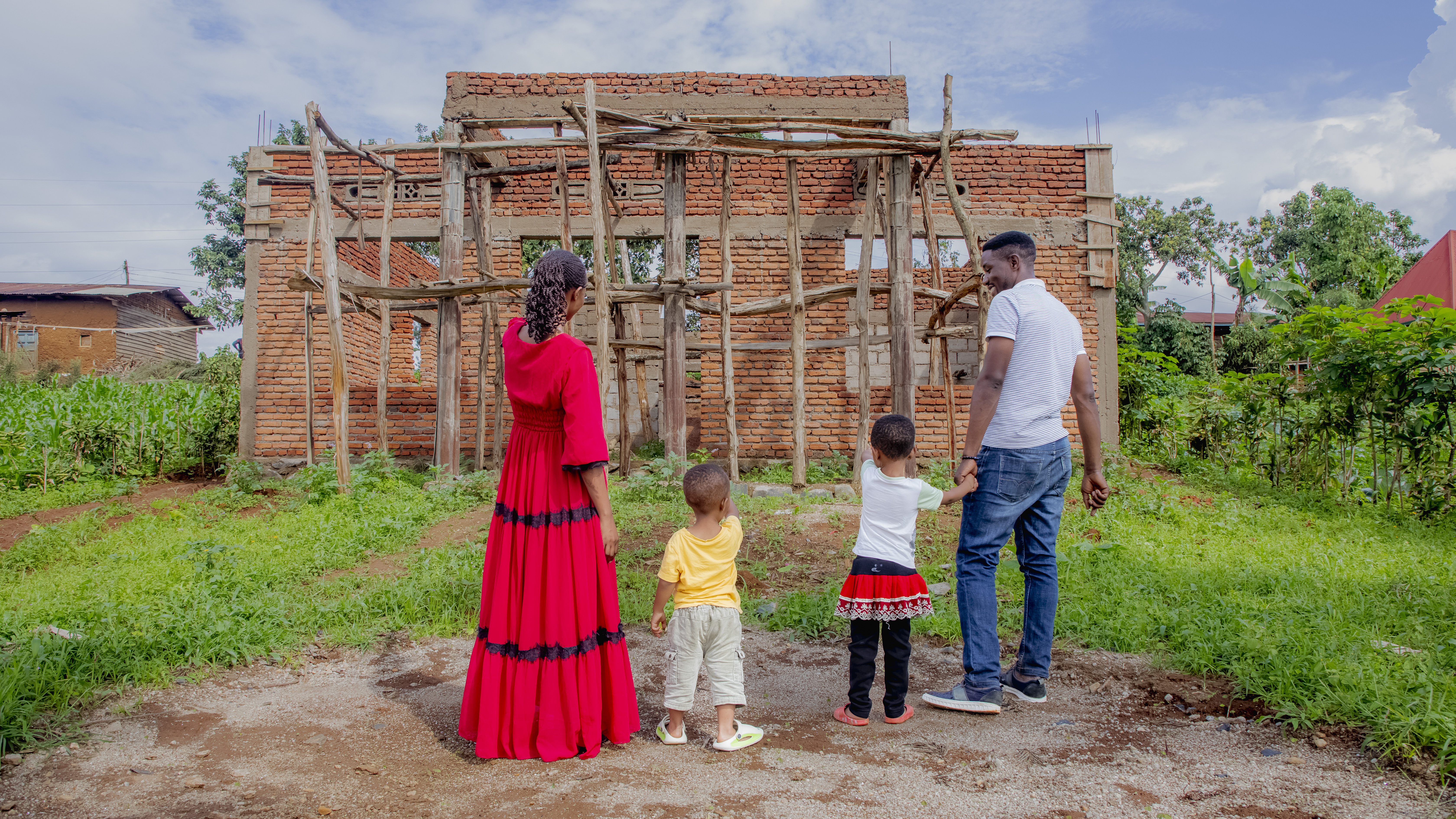 Anna, her husband and children at the cite were they are construction their house.