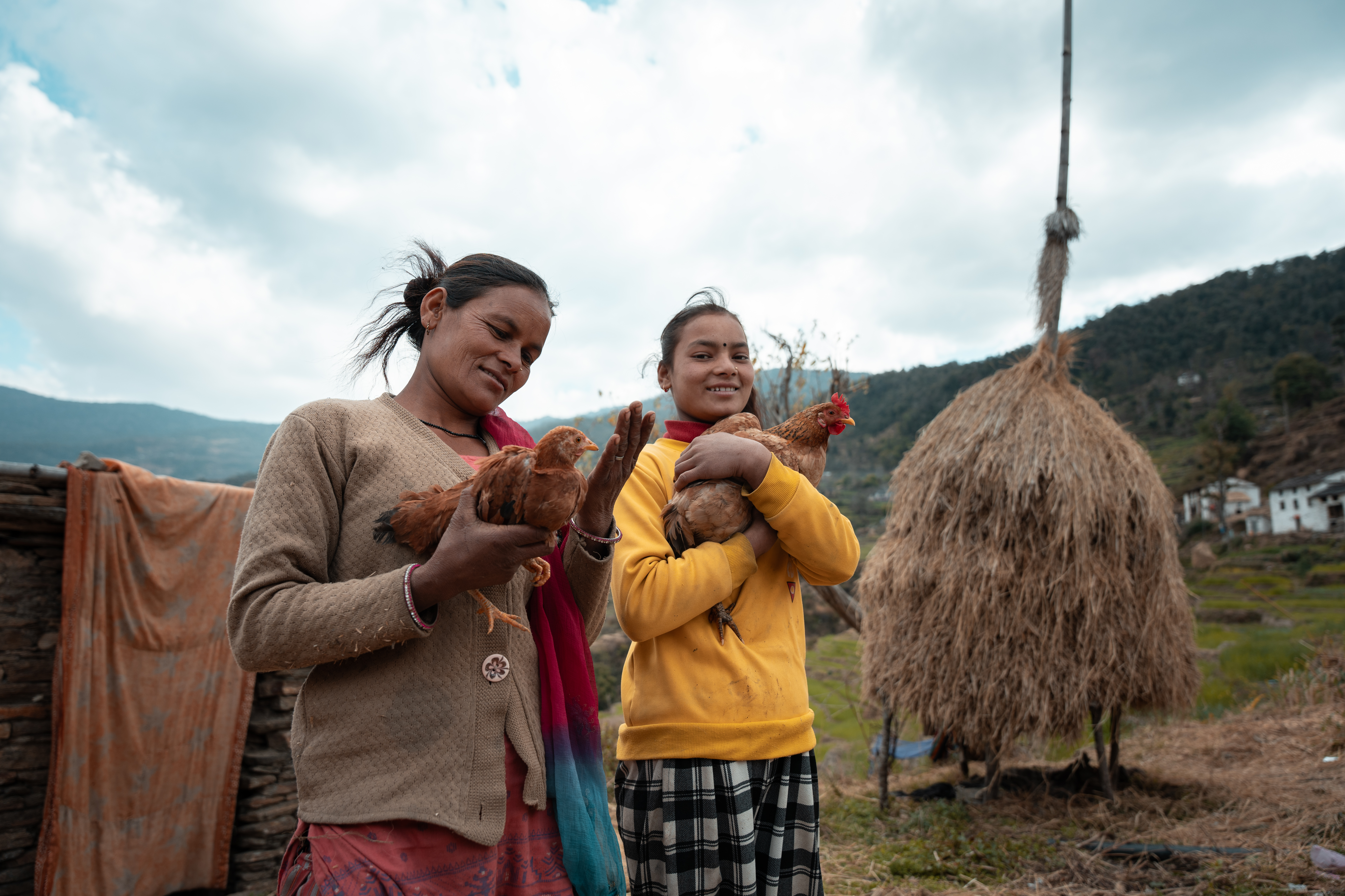 Amrita and her daughter hold chicken