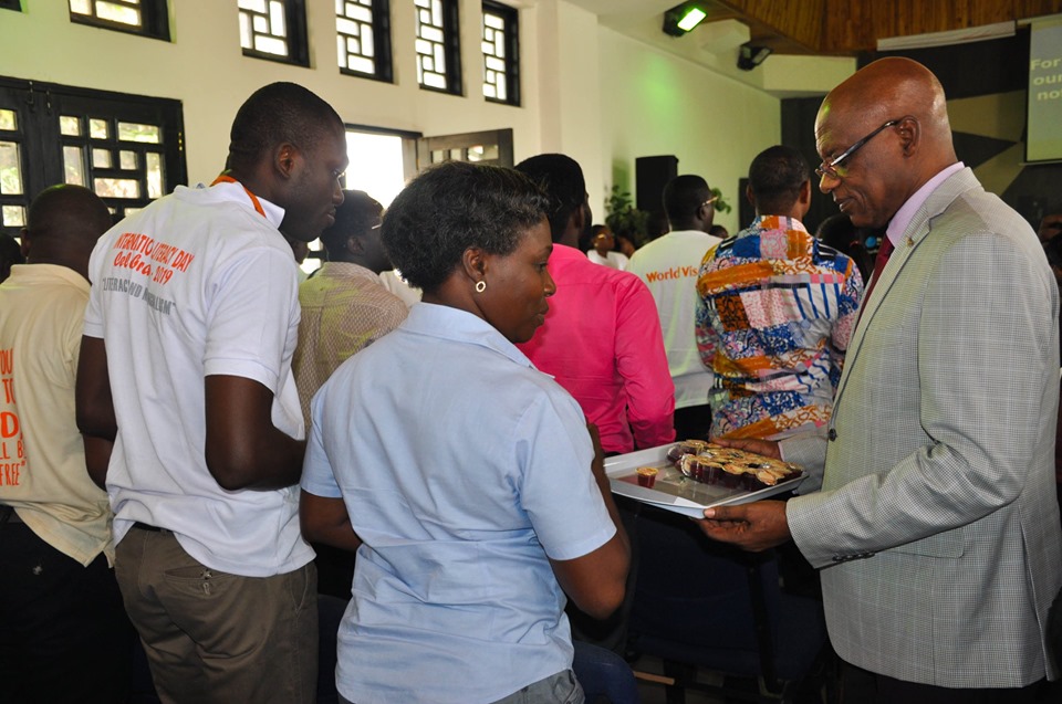 Board Chair, Baba Mahama, serving communion with some staff