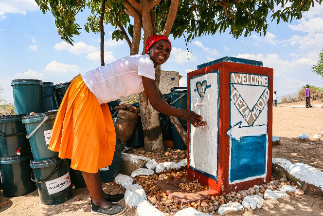 Chipo washing her hands at her handwashing station