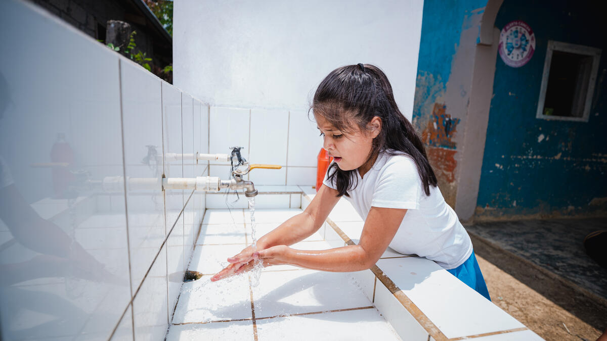 girl washing her hands in a school sink