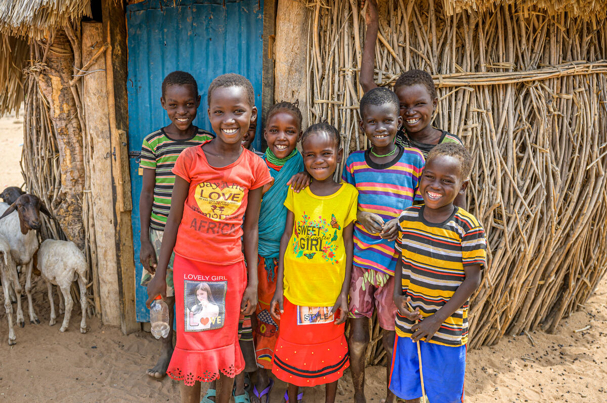 Simon and Pauline's children smiling outside their home.