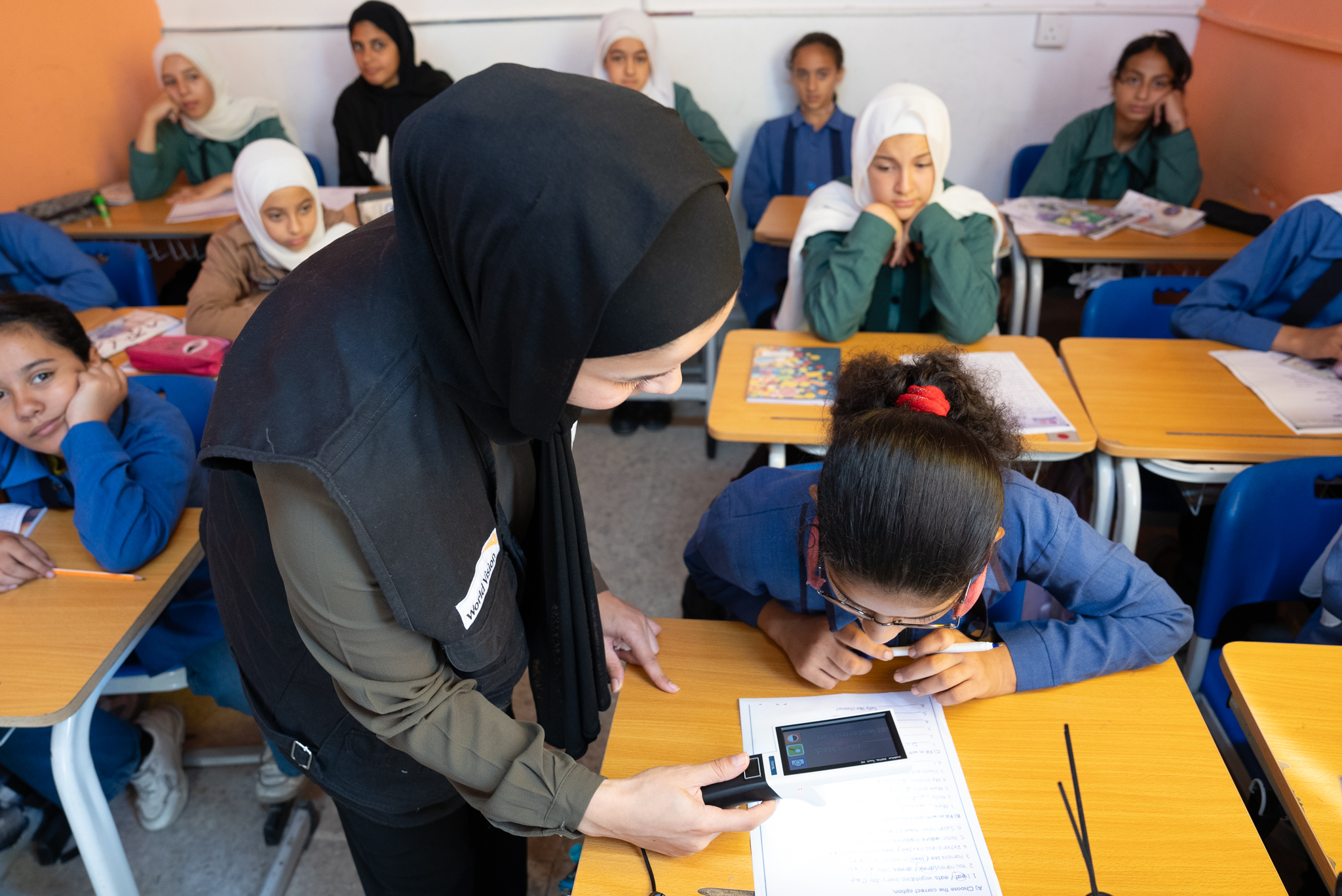 Dana* getting assistance from her teacher using the digital magnifier  World Vision Syria Response, Joanna Zreineh