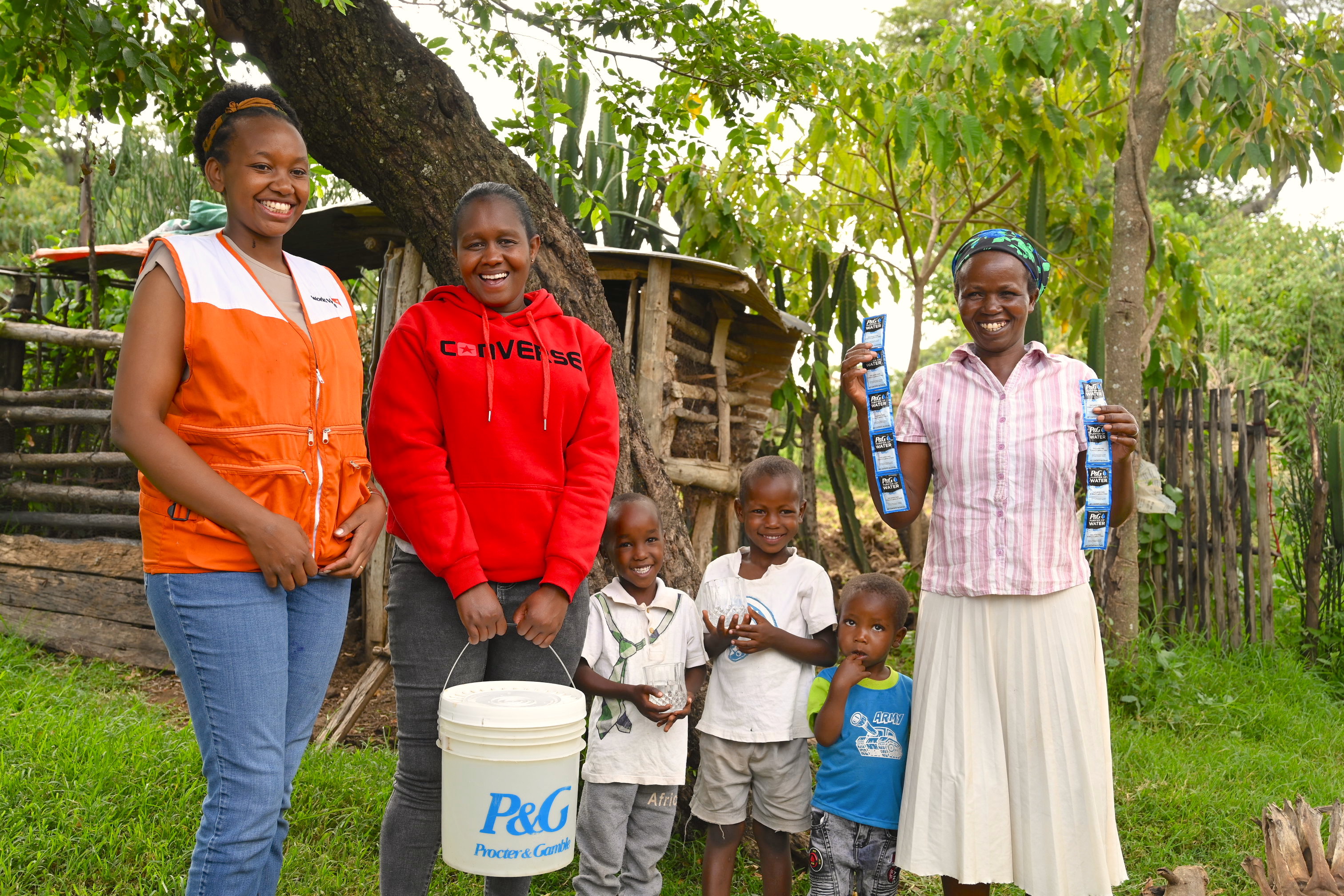 Lily, a mother of 11 in Bandaptai, poses (first right) and some of her children pose with Joan Tonui, World Vision Kenya WASHH specialist (first left) and Naomi Cherono, a community health officer in the County of Bomet.