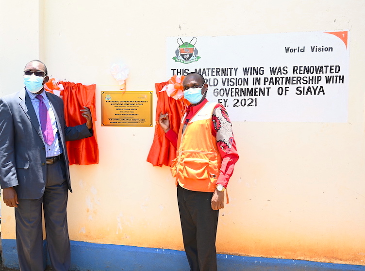 Joseph Tinkoi, the Lake Region Manager for World Vision Kenya and Dismas Wakla , the Siaya County Health Chief Executive outside the maternity wing renovated and equipped by World Vision