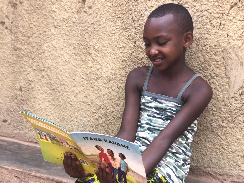 Esther happily reading a book while at home