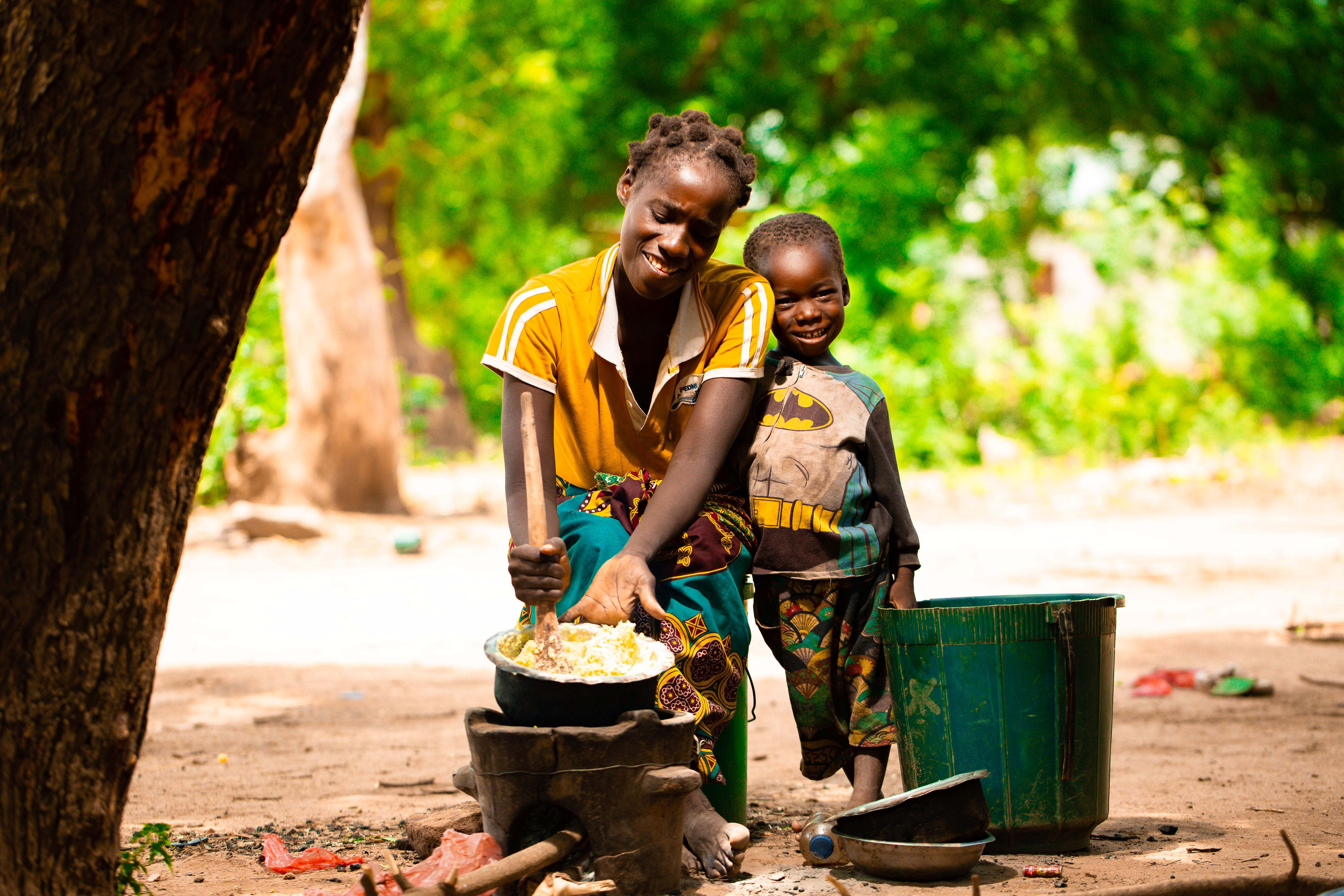 Fatima Taibu and her son Yankho (4years old) cooking their only food in four days made from sweet potatoes and Fatimas is pounding it to make Msima out of it. The only meal they will have for the day-4