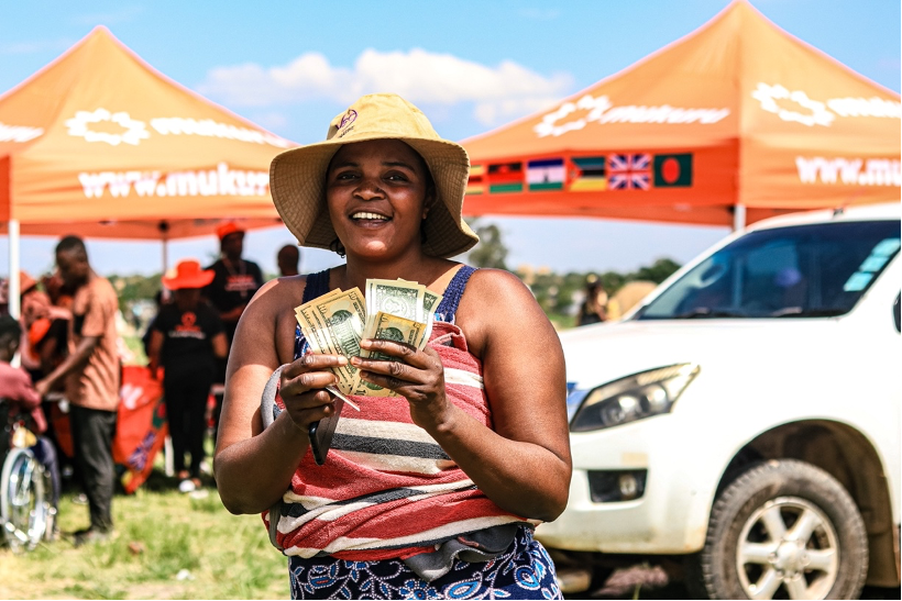 Gloria poses for a picture with her money she had received