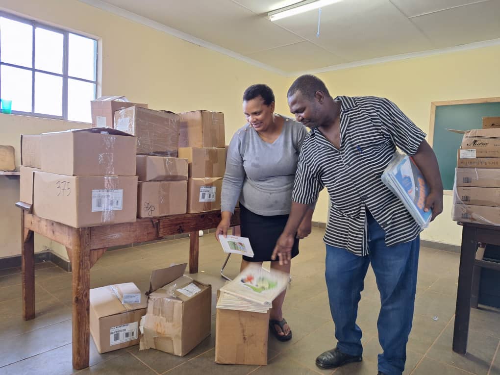 Headteacher Jeremiah Dludlu and teacher Tiny Dlamini unpack donated supplies for cooking practical lessons, ensuring students have the necessary resources for hands-on learning.