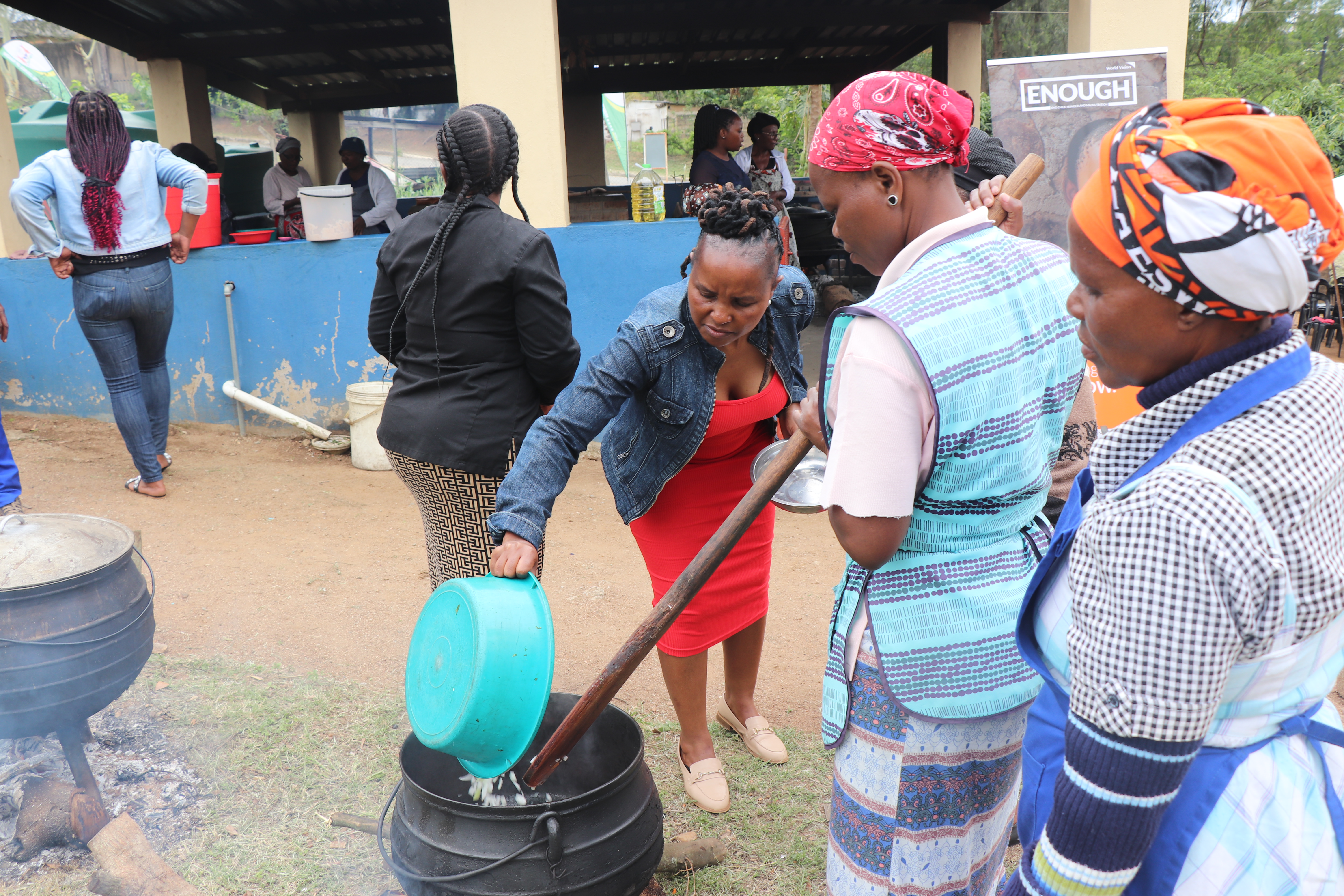 A Home Economics Extension Officer from the Ministry of Agriculture showing some of the caregivers who participated in a cooking demo aimed at capacitating them on how to prepare great-tasting vegetables without losing their nutrients.