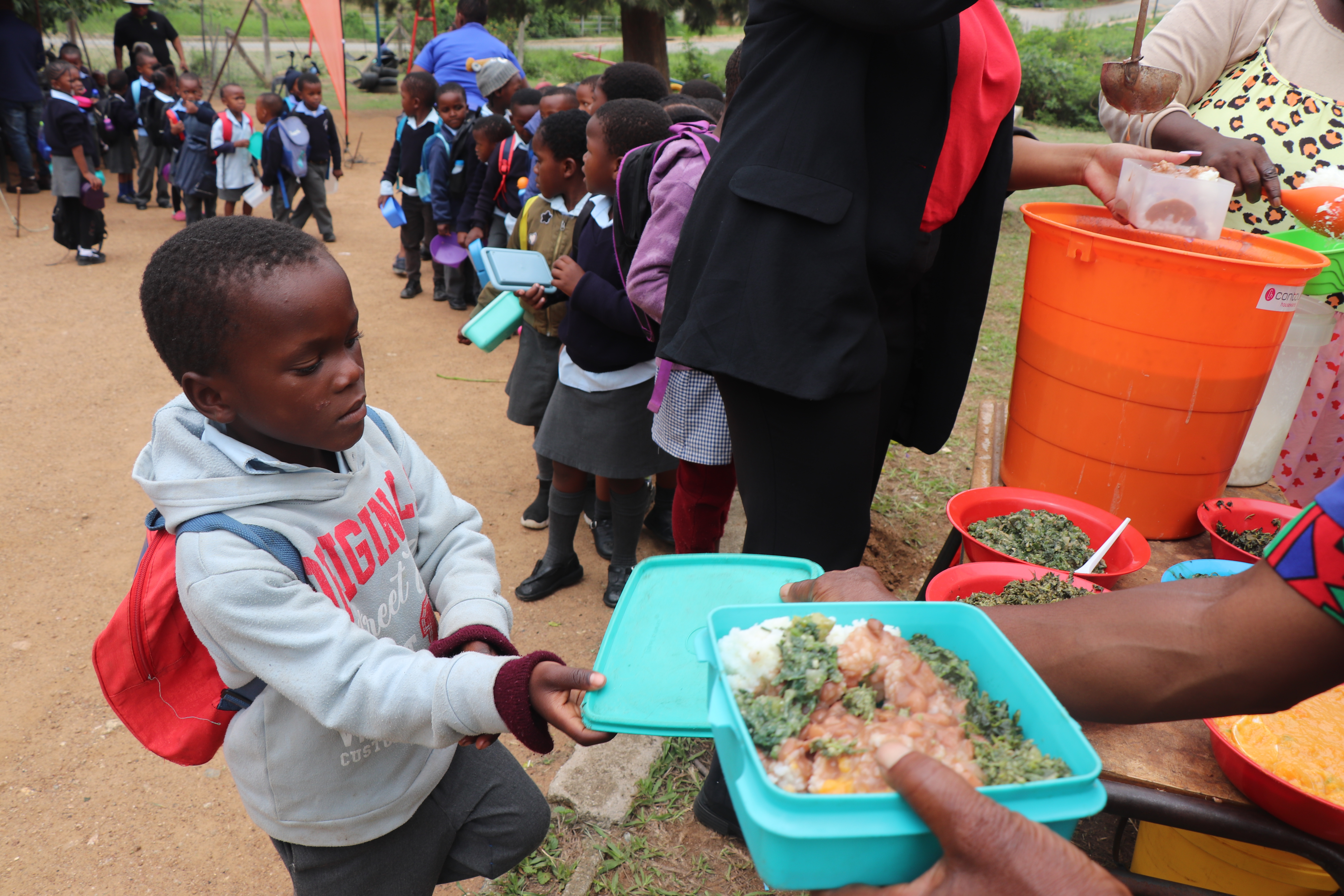 A young boy receiving his food, which was prepared by neighbourhood care point caregivers under the Manzini Municipality during a cooking demo facilitated by Home Economics Extension Officers supporting a World Vision-implemented Taiwan Africa Vegetable Initiative (TAVI) Project, funded by the World Vegetable Center. 