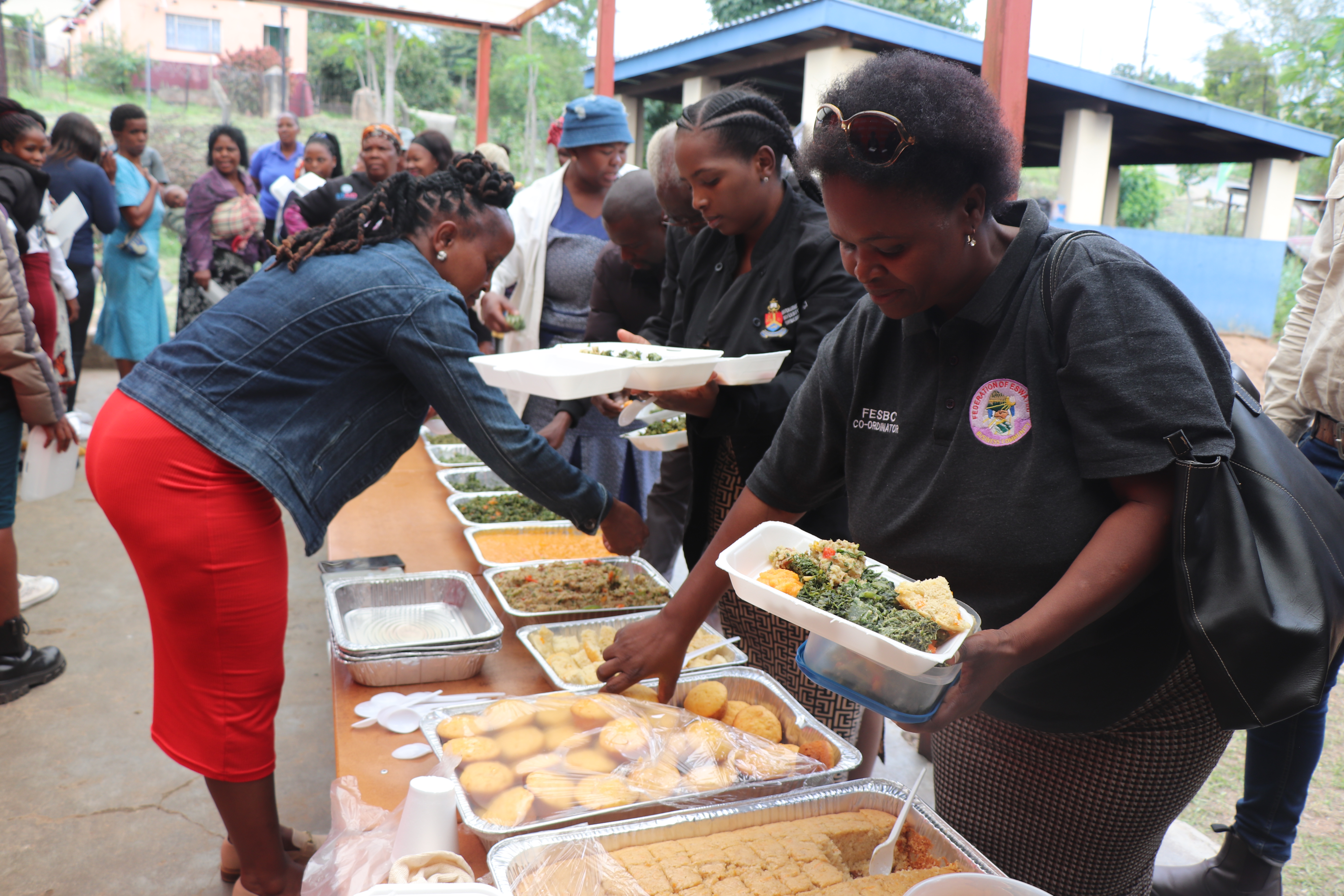 – Participants during a cooking demo tasting the variety of foods prepared by Manzini neighbourhood care point caregivers, facilitated by Home Economics Extension Officers supporting a World Vision-implemented Taiwan Africa Vegetable Initiative (TAVI) Project, funded by the World Vegetable Center.