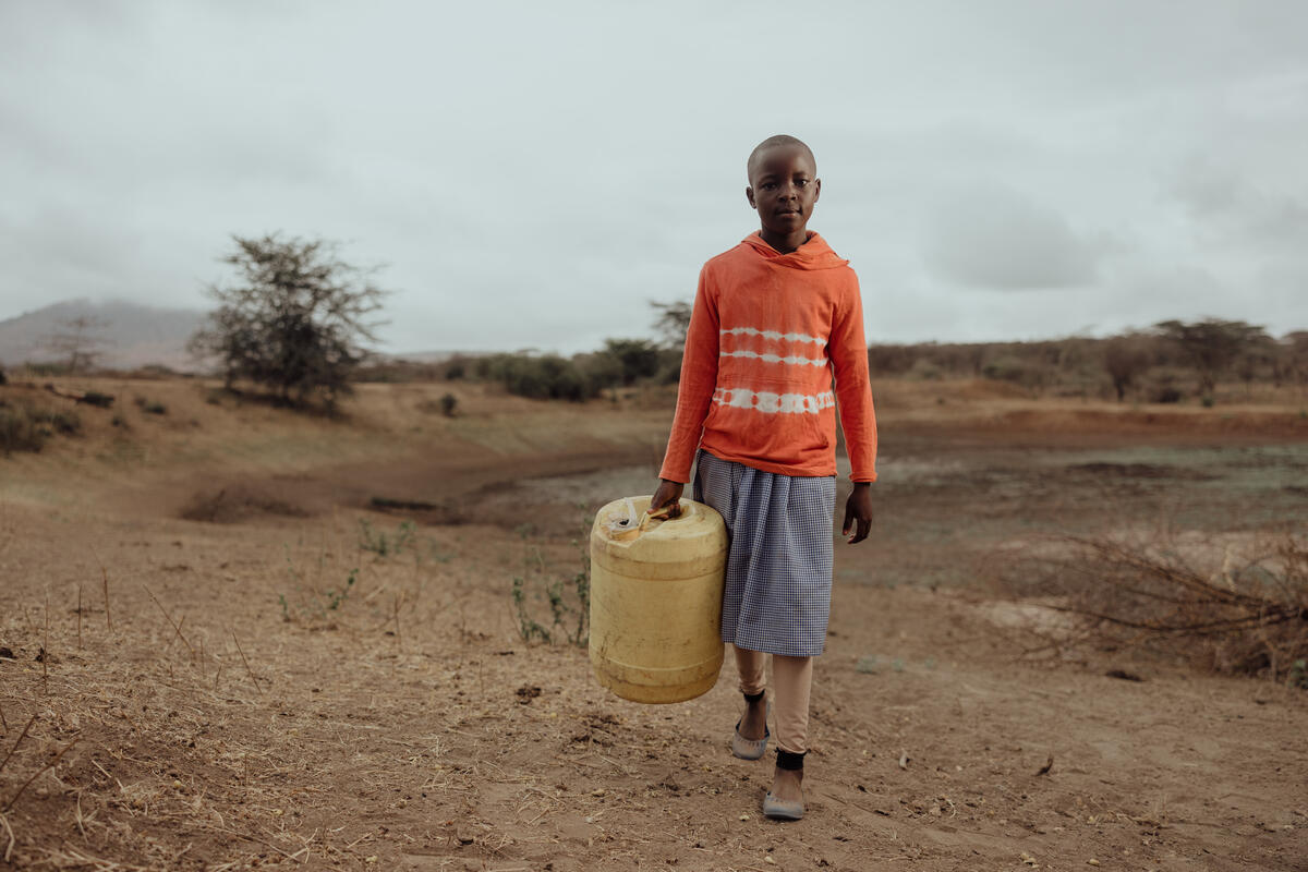 A child from Kenya bringing water