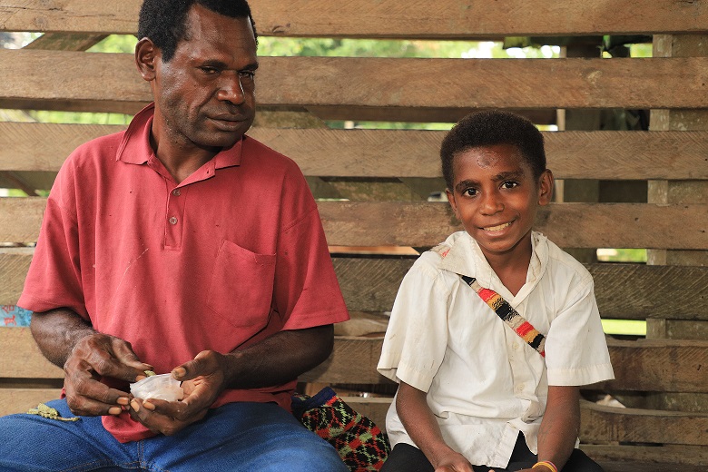 Raymond and his son, Ryan. Ryan is a beneficiary of World Vision’s education project in his community. Because of World Vision’s intervention last year, Ryan can now read and speak better English. Hi parents are also members of a Savings Group where they have saved some money which has enabled Ryan to attend school this year. Picture: Steven Doe