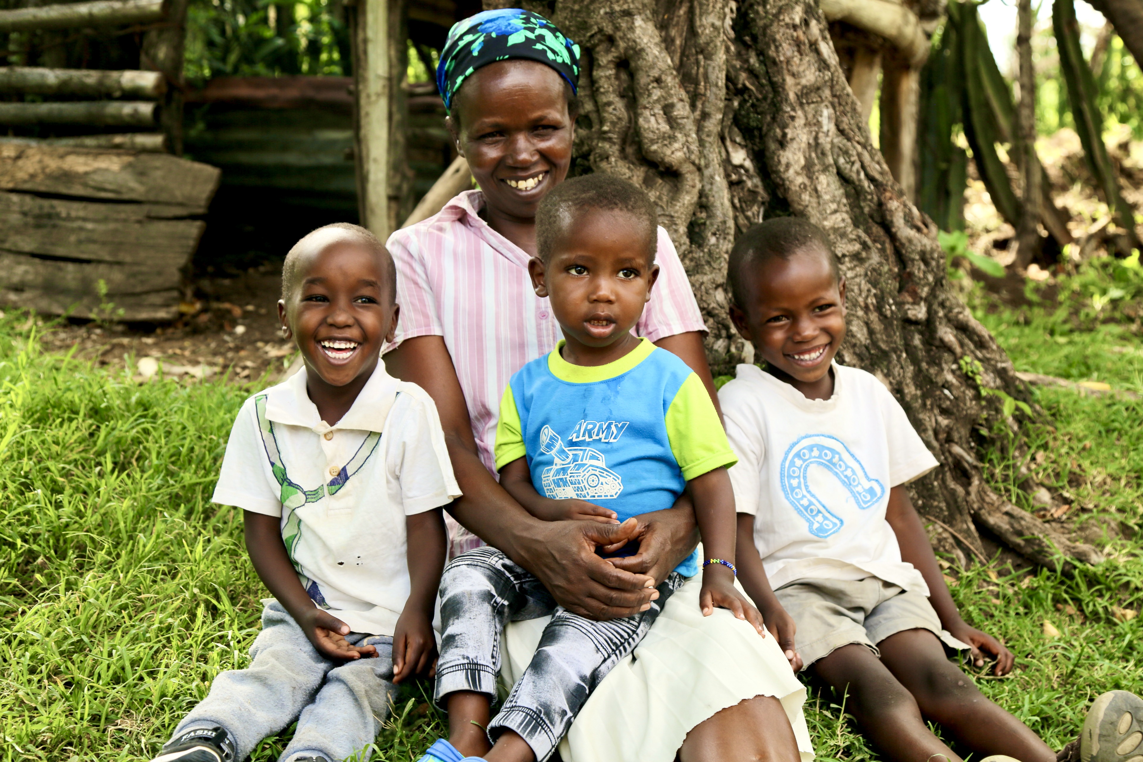 Lily poses with her 3 children in Bomet after sharing how a water purification solution provided by P&G and World Vision Kenya has enabled her and her family enjoy clean, safe water. Previously, her children suffered from diseases like typhoid and cholera due to drinking contaminated water from a nearby river.