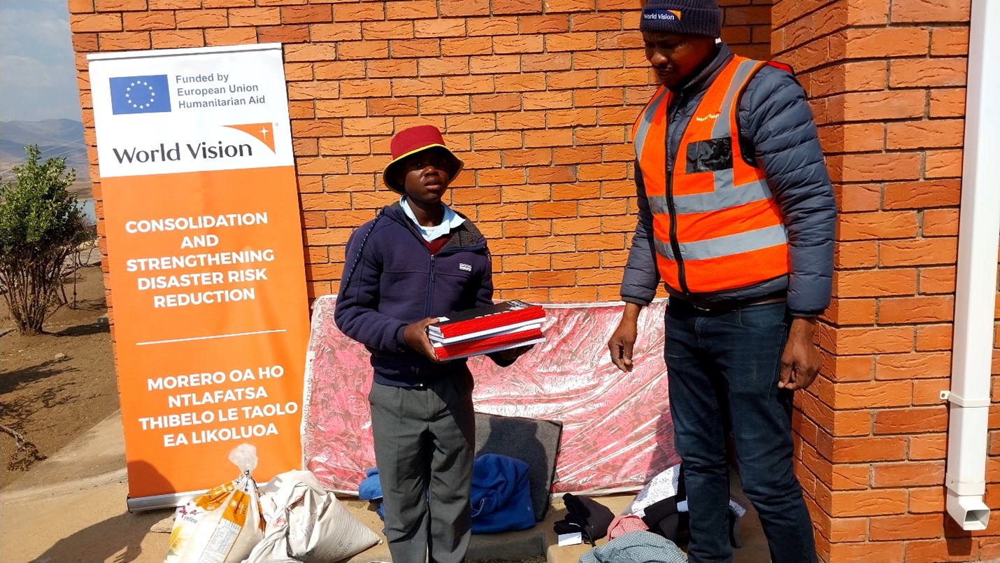 Seeti in his new school uniform, receiving books from World Vision, ready to continue his education with renewed hope