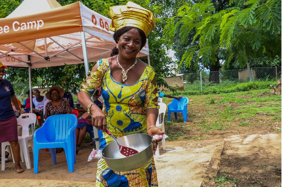 Maman Chike, one of the Community Leaders from TRS holding some of the kitchen utensils that was donated by World Vision Zimbabwe.