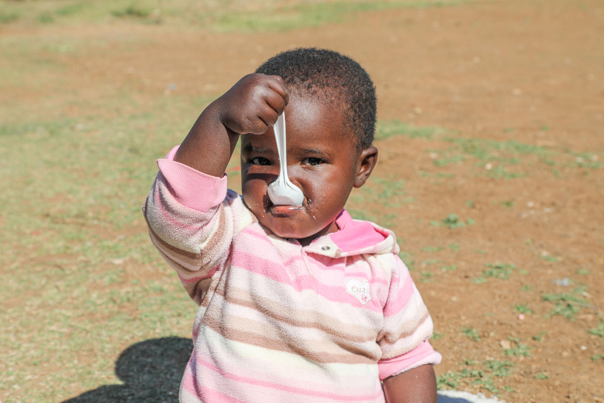 A child in Africa eats from a spoon