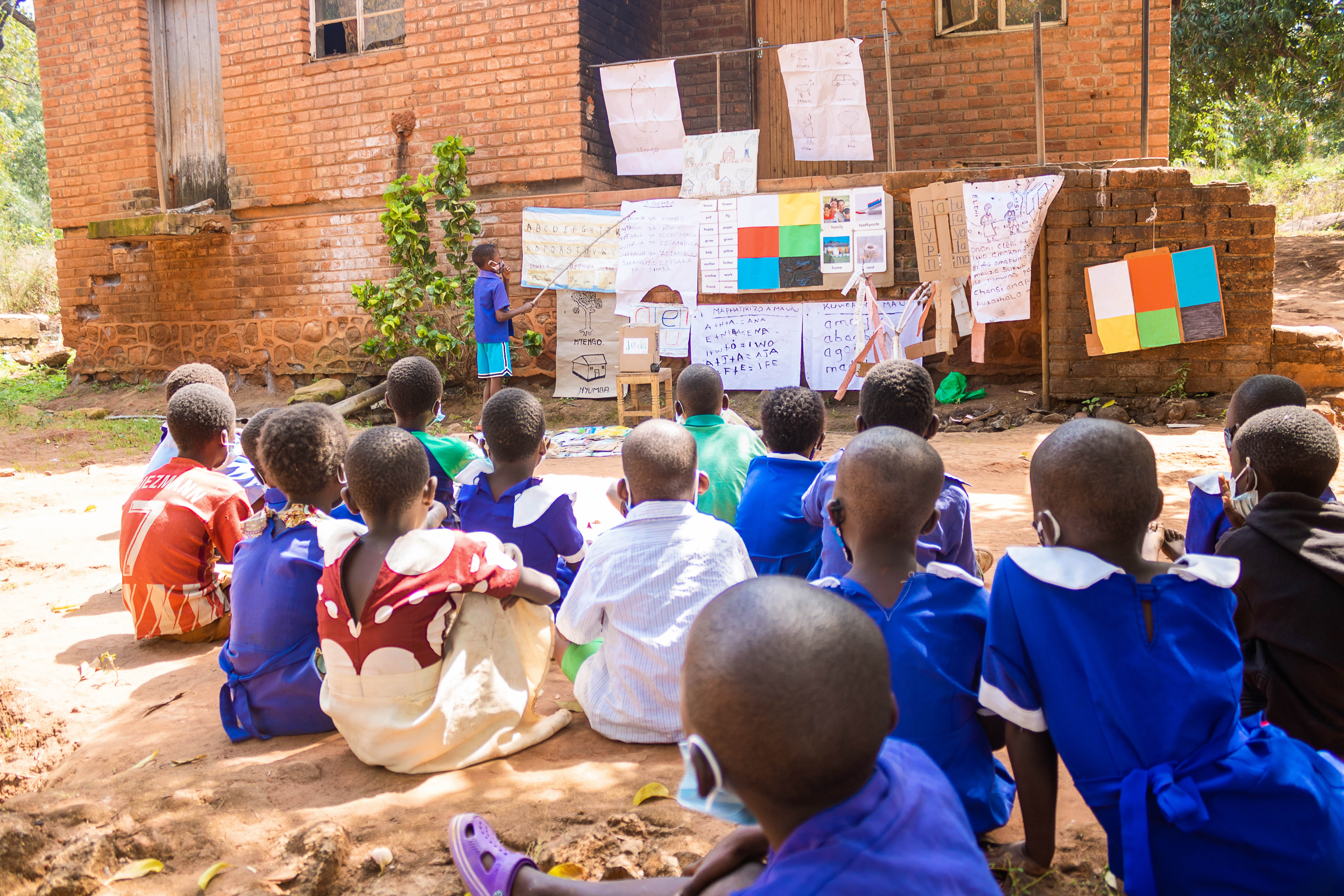 Malawian lad teaching others how to read