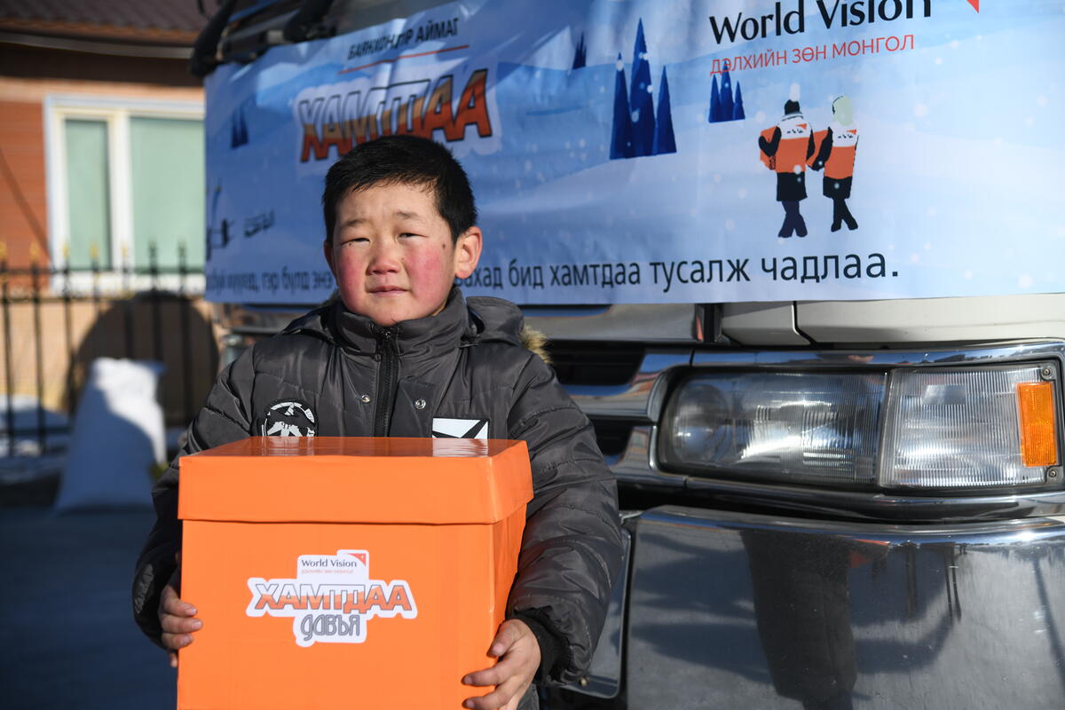 Mongolia boy holding World Vision to deal with the Dzud