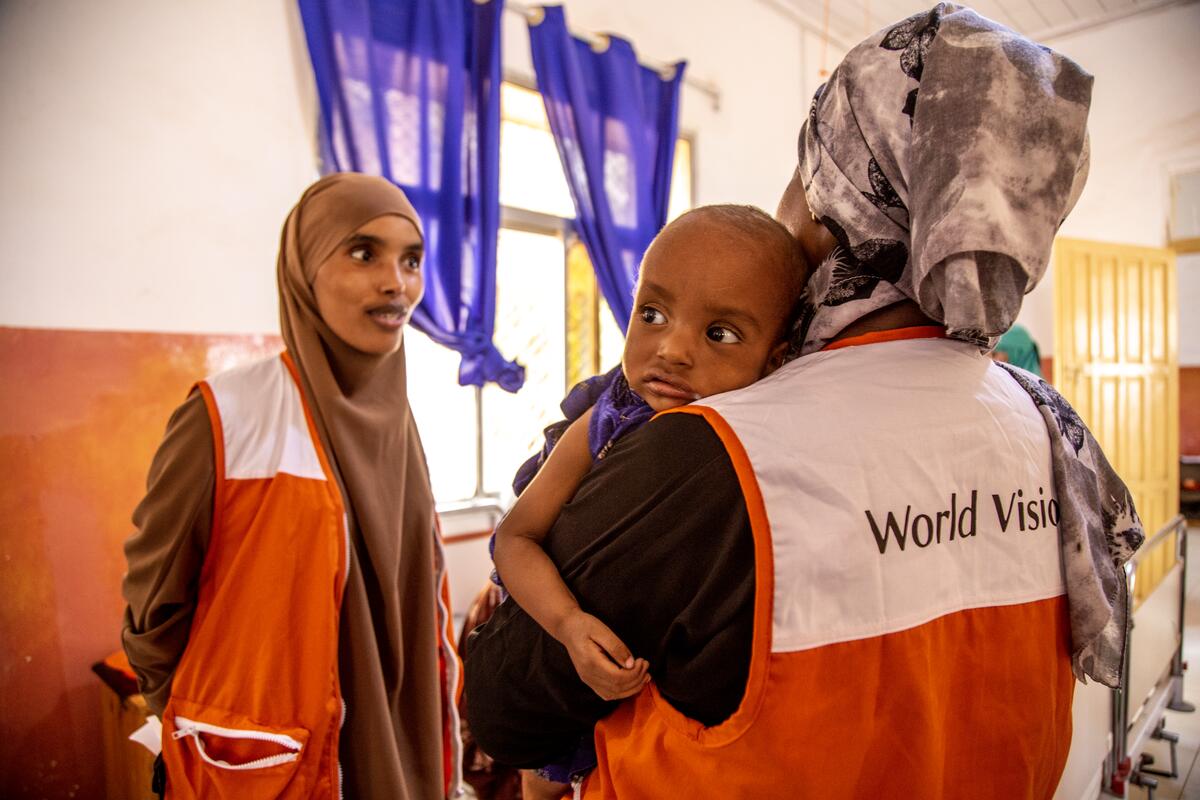 Above: Global Hunger Response Director, Mary Njeri, comforts a child while talking to a World Vision staff member at a mobile clinic in Baidoa, Somalia.  / © World Vision