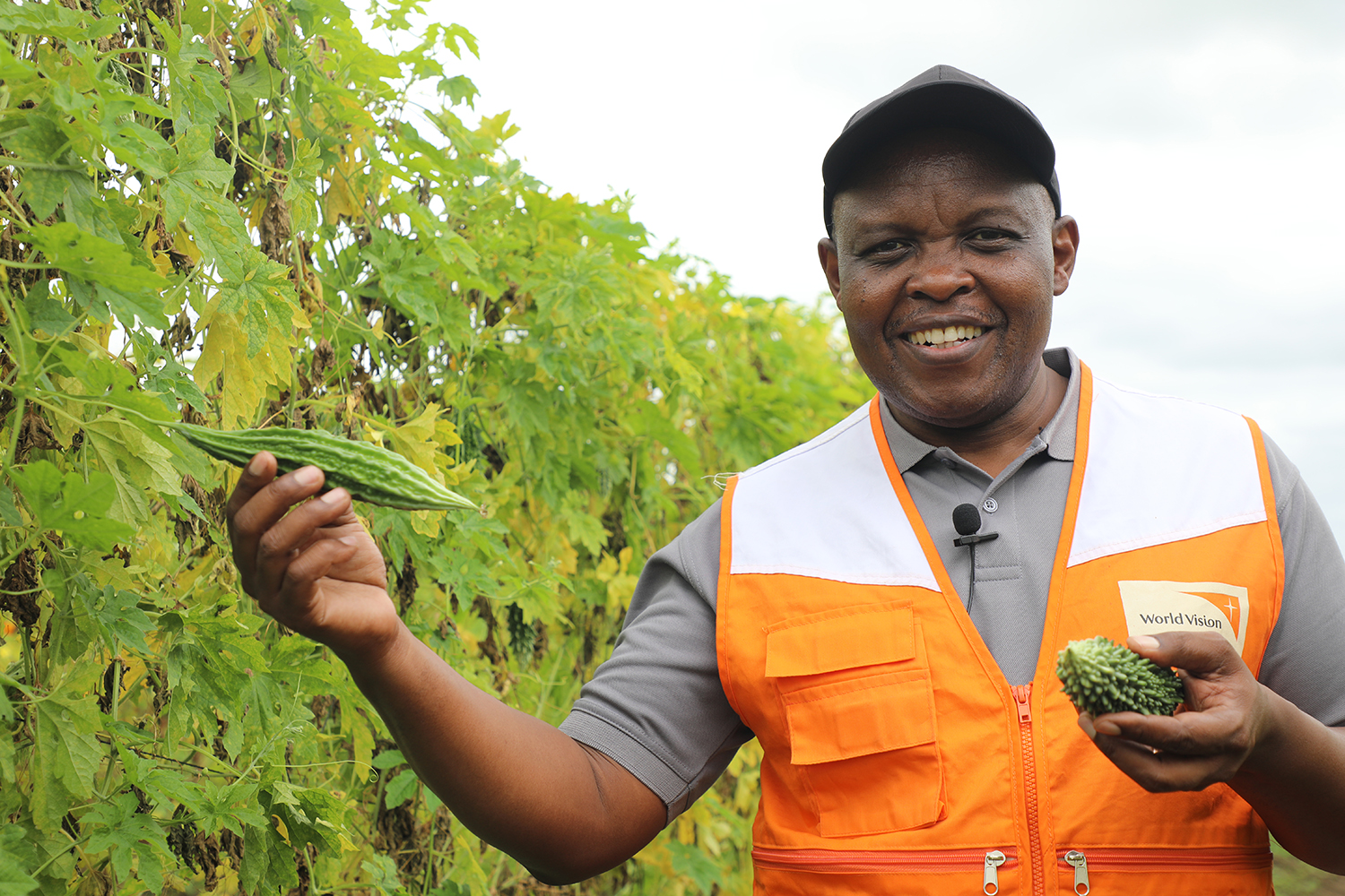 World Vision staff in Tanzania holds up a bitter gourd