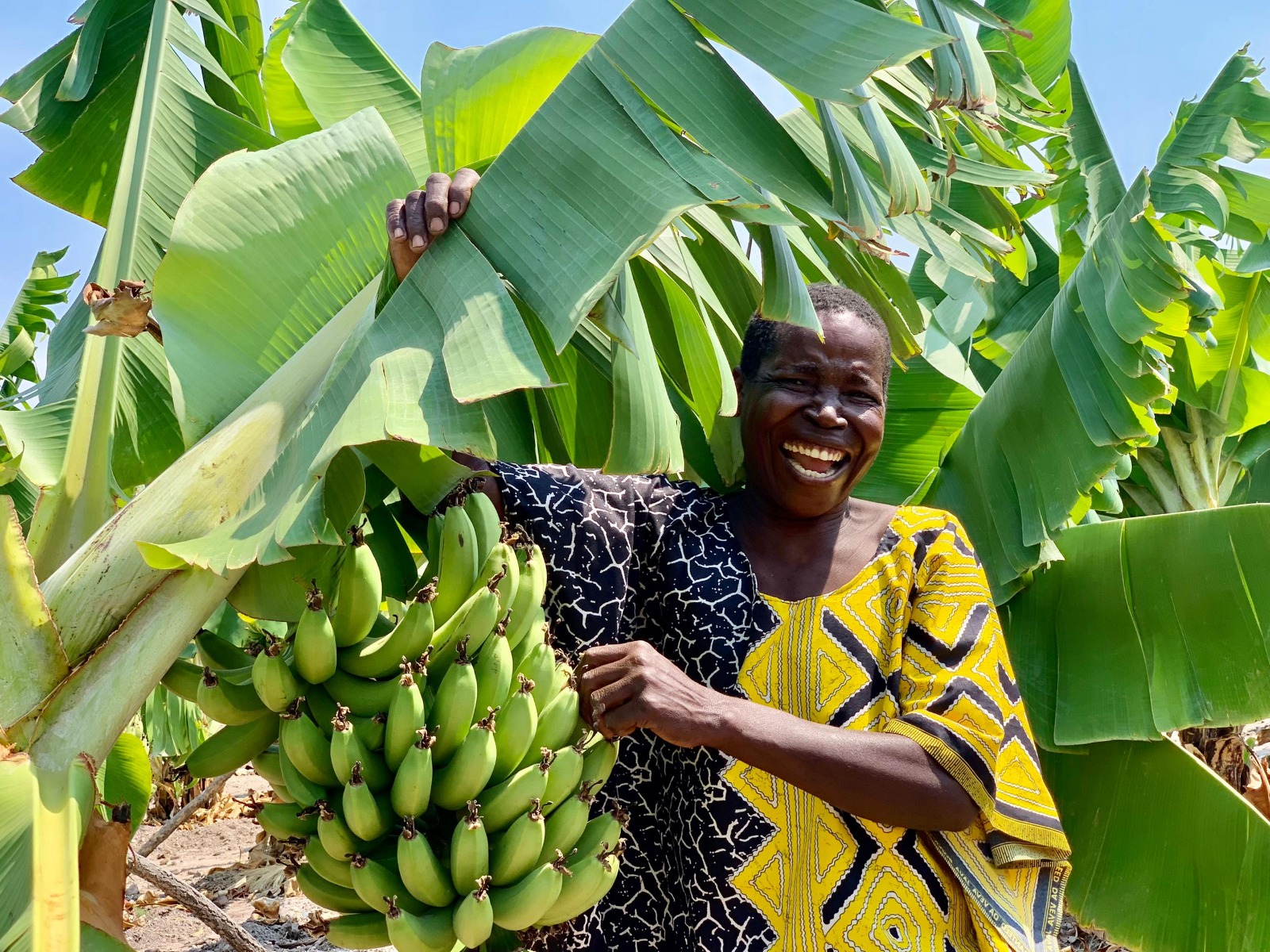 Chipo Mangisi poses for a photo besides some of her bananas