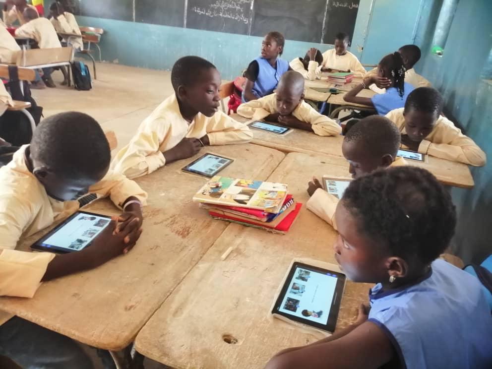 Children participating in class with their tablets.