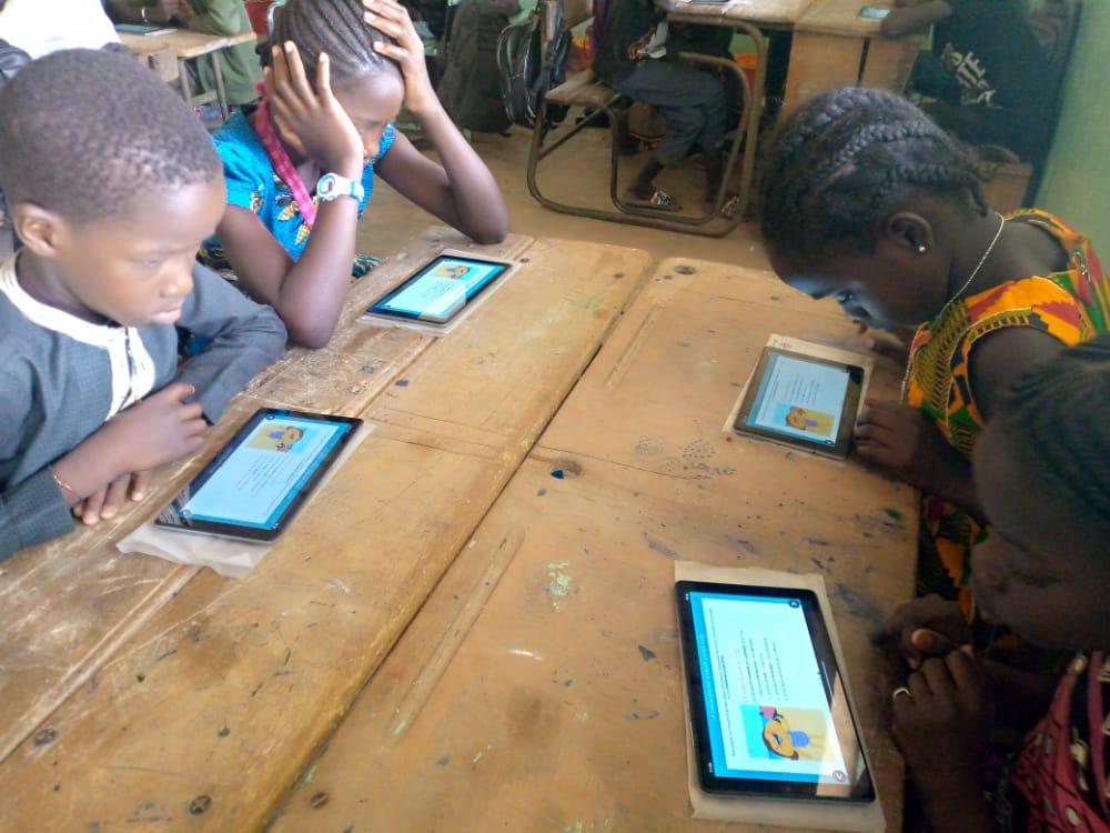 Children reading on their tablets.