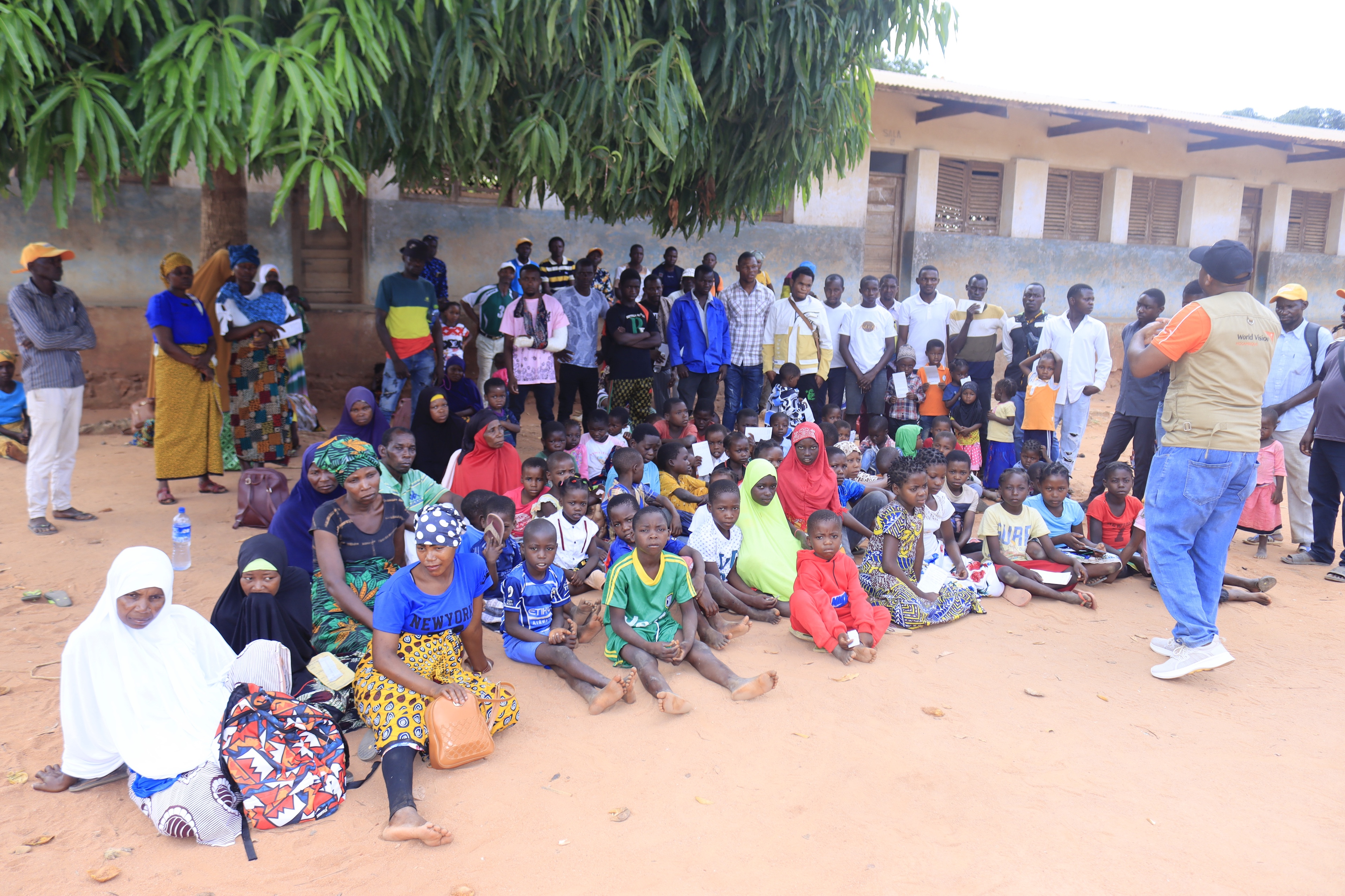 World Vision staff interacts with survivors of the Cyclone Chido, moments before the distribution of aid.