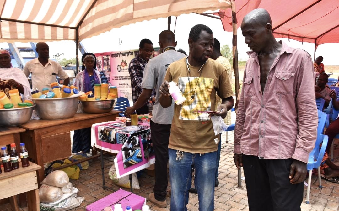 Agro-input dealer explaining effectiveness and usage of agro-chemicals on exhibition