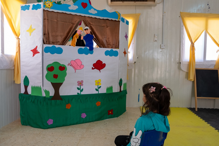 One of the child participants watching a puppet show. World Vision Syria Response, Joanna Zreineh