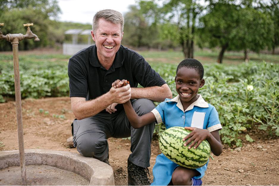 Mark Kelly poses for a picture with Kelly in the Mutwe Nutritional Garden