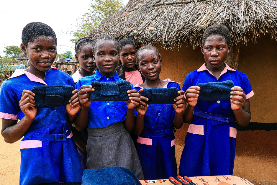 Girls hold their handmade washable sanitary pads 