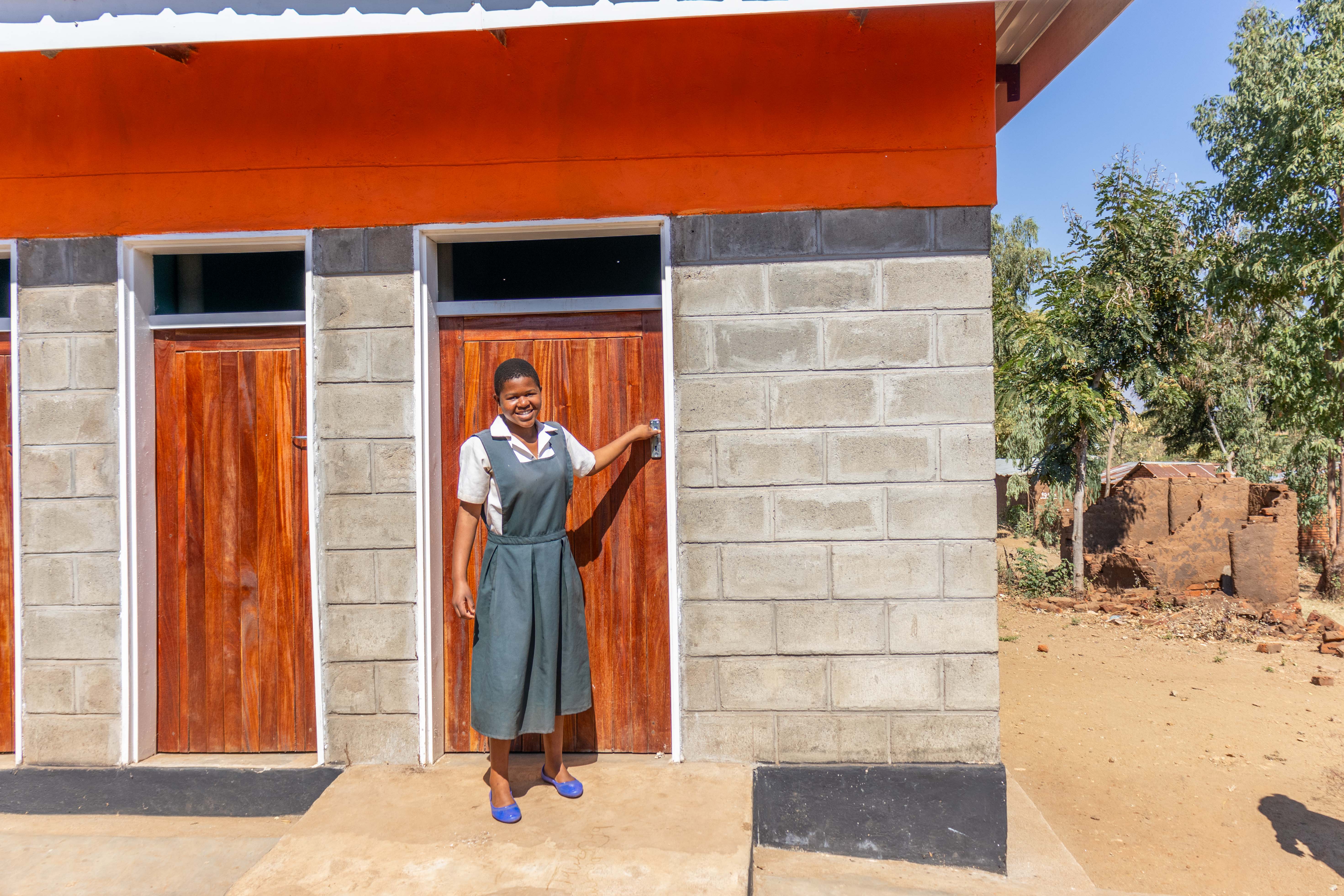 Kettie, 16,  coming out of the washrooms constructed by World Vision