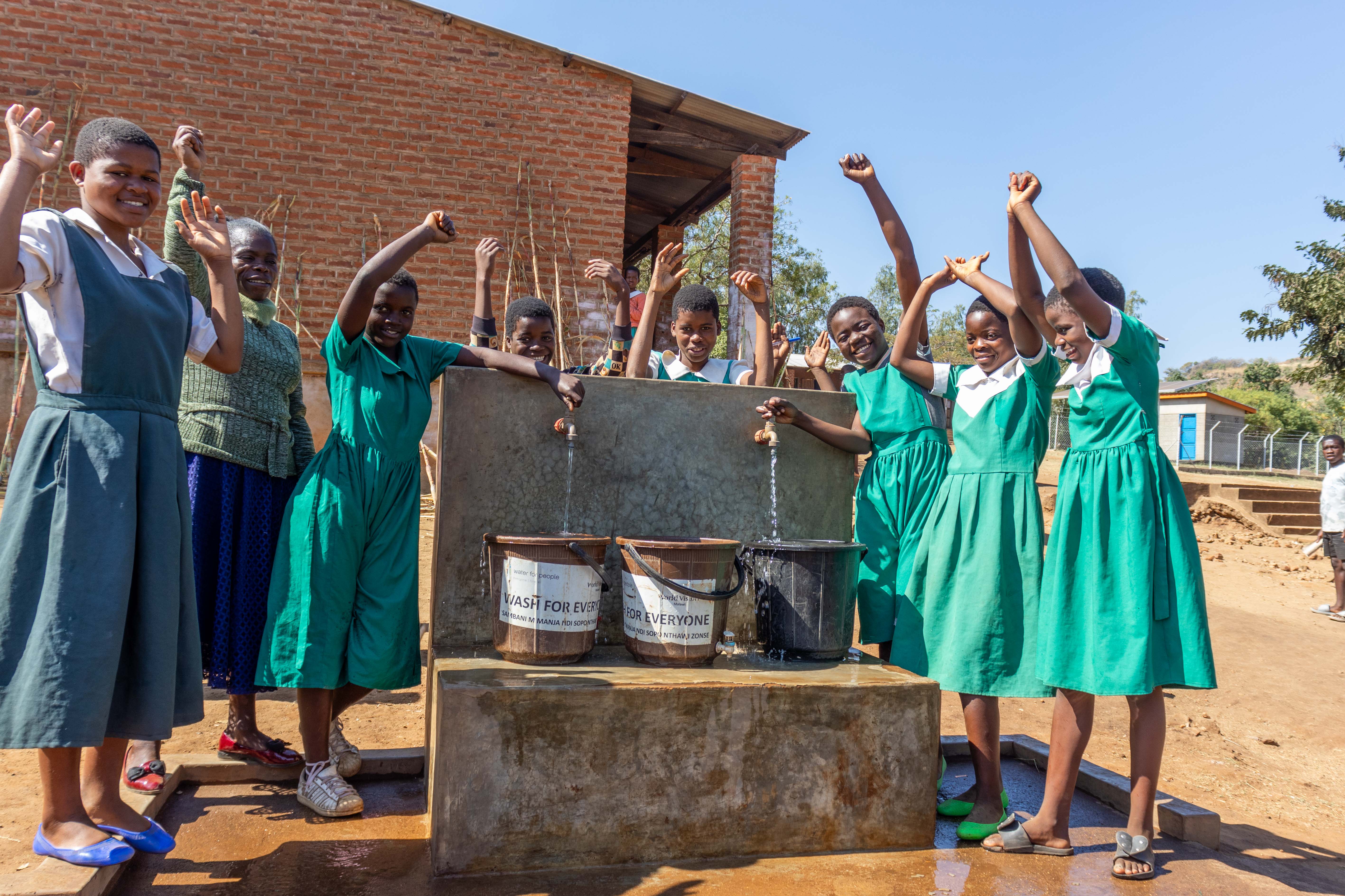 Kattie and her friends celebrating  water availability at their school.