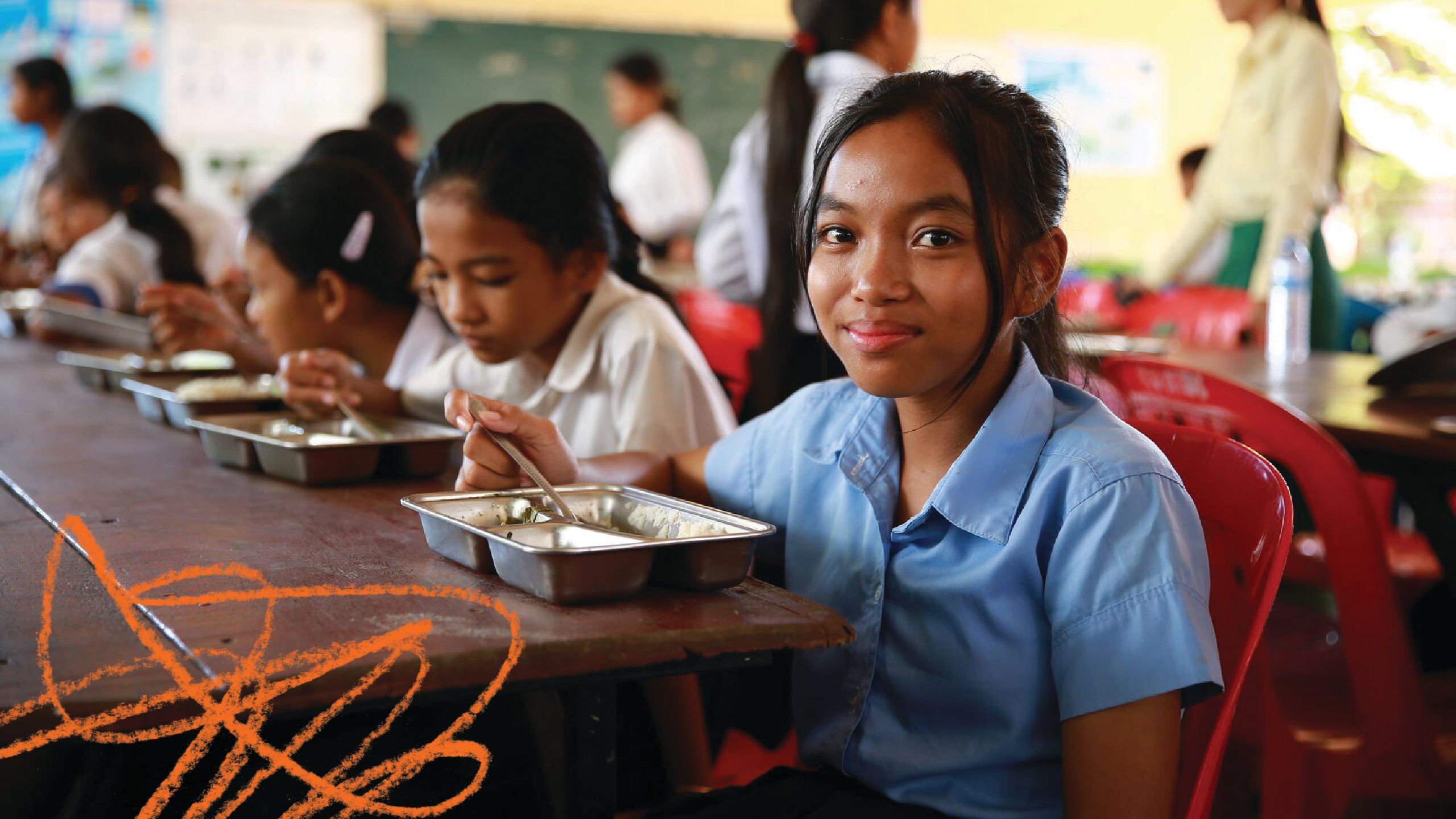 Chandy eats her meal with her classmates at school